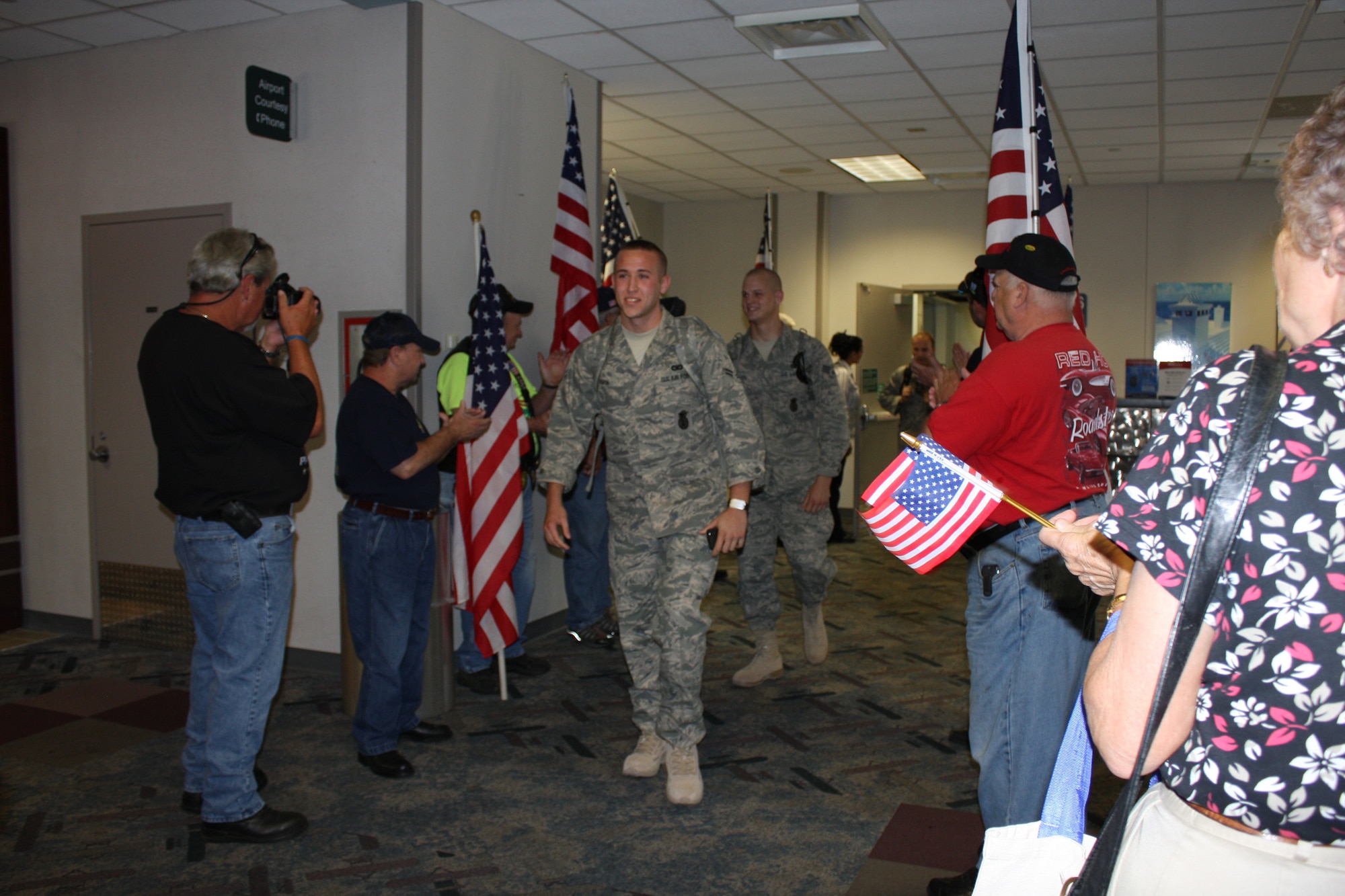 WRIGHT-PATTERSON AIR FORCE BASE, Ohio – Airman 1st Class Kevin Horn, 445th Security Forces Squadron, leads 11 fellow reservists from the SFS through the arrival gate at the Dayton International Airport Aug. 6.  The reservists just returned from a 6-month deployment to Southwest Asia. Airman Horn’s brother just deployed with 12 SFS reservists in July.  (U. S. Air Force photo/Stacy Vaughn)