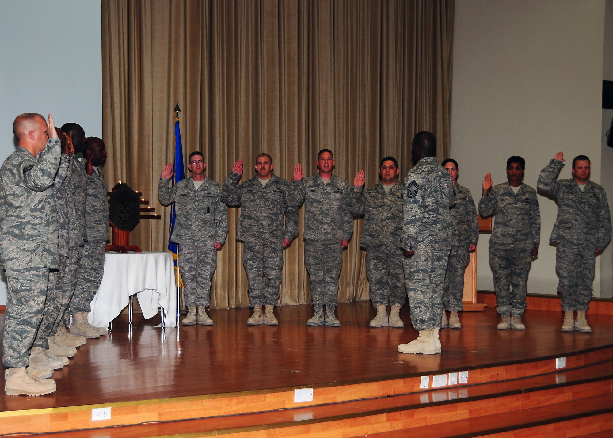 SOUTHWEST ASIA ? Chief Master Sgt. Marcus R. Snoddy, 386th Expeditionary Mission Support Group superintendent, leads a group of 13 non-commissioned officers from the 386th Air Expeditionary Wing in the Senior NCO charge during their Senior NCO induction ceremony held here Aug. 8. (U.S. Air Force photo/Tech. Sgt. Tony Tolley)  