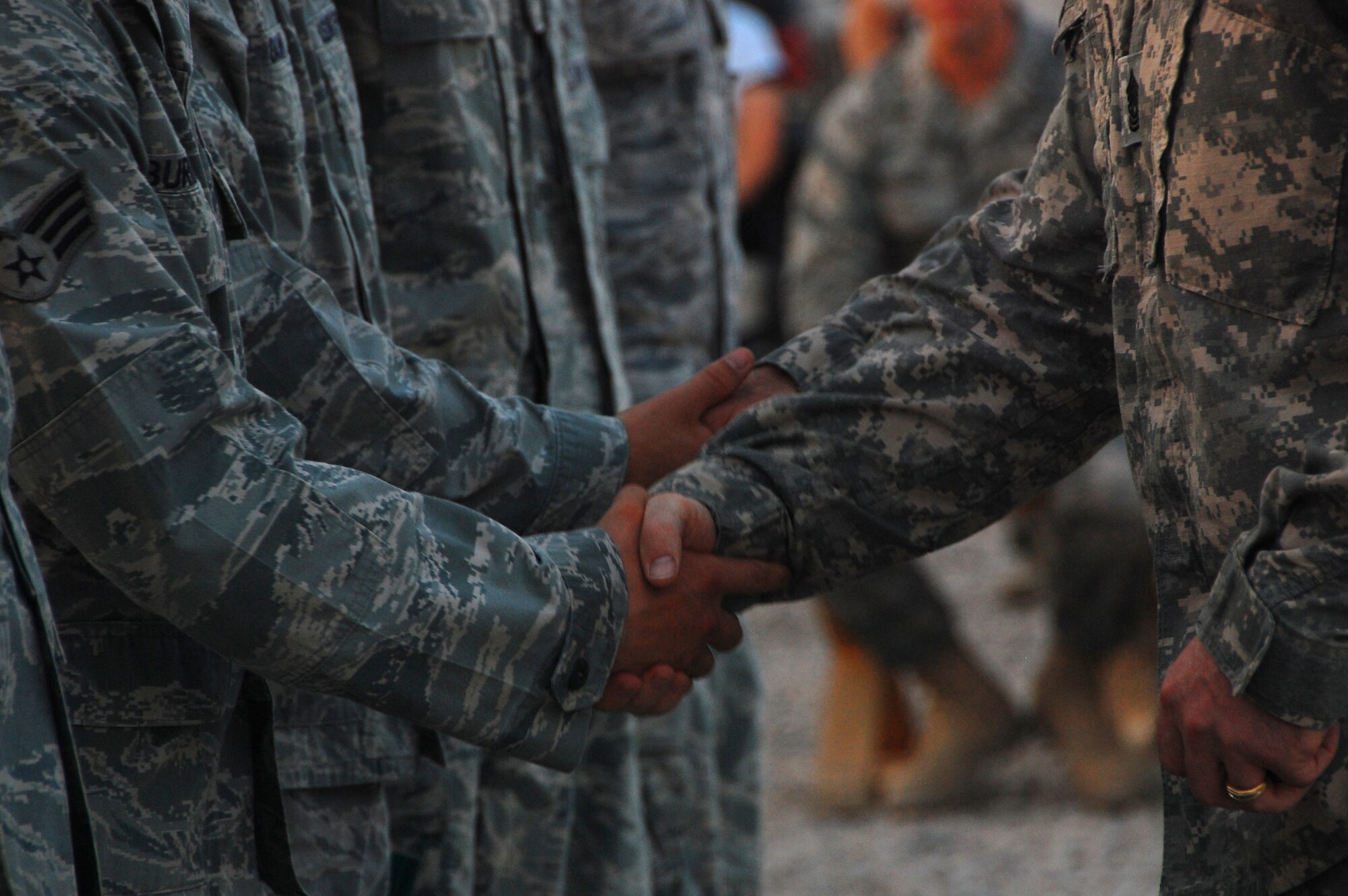 CAMP BUCCA, Iraq ? Army Lt. Col. Brad Bishop, 168th Military Police Battalion commander, and Command Sergeant Maj. James Smith, 168th MP Battalion command sergeant major, shake the hands of Airmen from the 887th Expeditionary Security Forces Squadron during an end-of-tour ceremony Aug. 10. The Airmen were responsible for visitation operations at Camp Bucca, Iraq. More than 180,000 family members were escorted on base to visit with their loved ones being detained at the theater internment facility here. (U.S. Air Force photo/Staff Sgt. Shaun Emery)