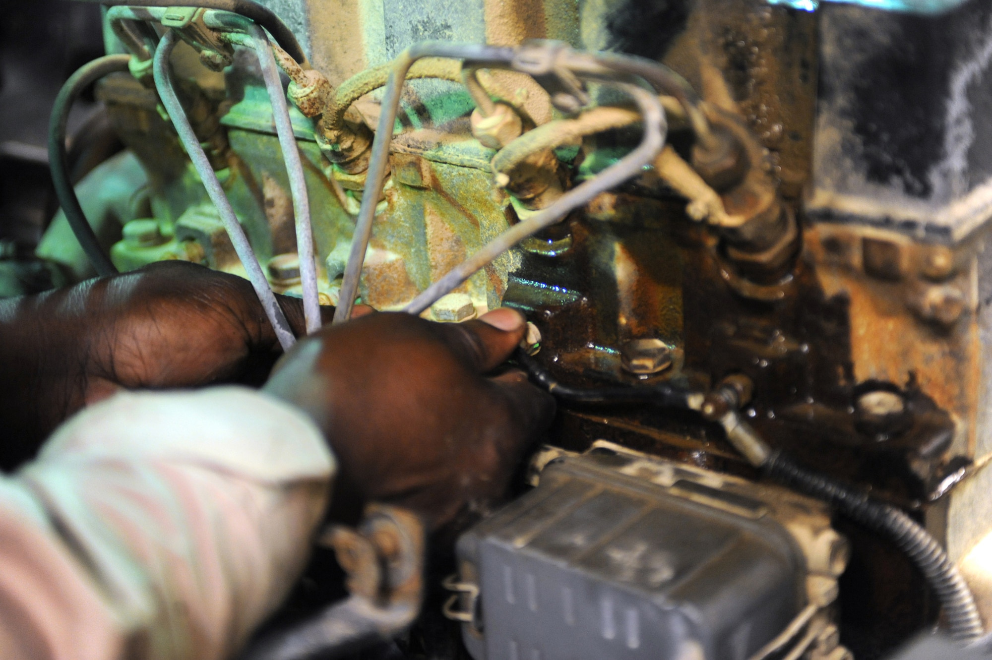 SOUTHWEST ASIA -Staff Sgt. Derrick Wallace, 380th Expeditionary Logistics Readiness Squadron, checks the wiring on a baggage conveyor engine Aug 11. Sergeant Wallace, is a heavy vehicle mechanic deployed from the 106th Rescue Wing at Gabreski Airfield, N.Y., and hails from Queens, N.Y. (U.S. Air Force photo/Tech. Sgt. Charles Larkin Sr)
