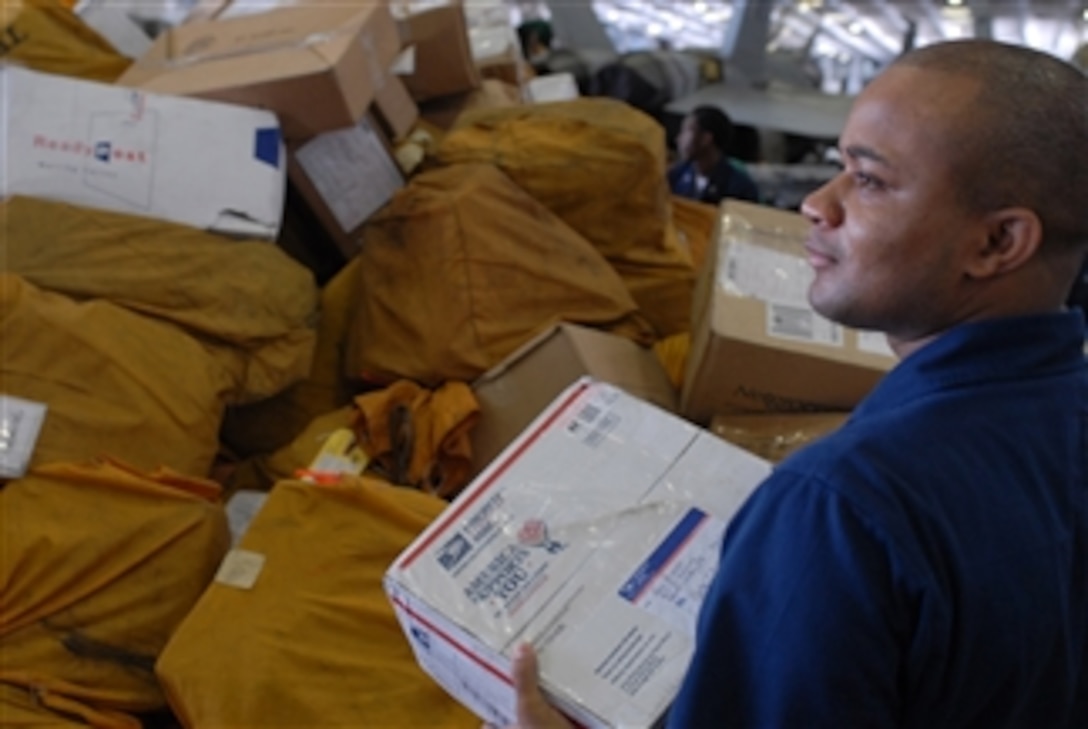 U.S. Navy Petty Officer 1st Class Cornelius Burr sorts mail in the hangar bay of the aircraft carrier USS Ronald Reagan (CVN 76) in the Gulf of Oman on Aug. 7, 2009.  The Ronald Reagan received more than 80 pallets of mail.  The Ronald Reagan is deployed to the U.S. 5th Fleet area of operations.  