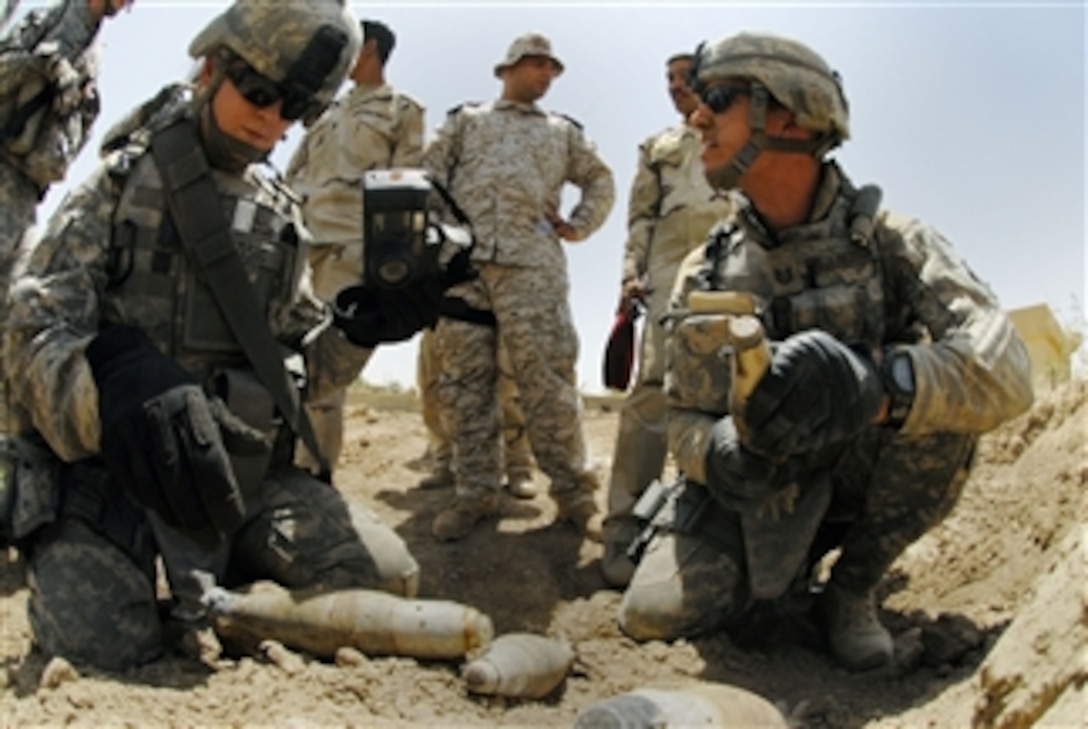 U.S. Army soldiers from the 787th Explosive Ordnance Disposal Company, 79th Explosive Ordnance Disposal Battalion, Task Force Troy assist Iraqi army soldiers from the 2nd Battalion, 24th Brigade, 6th Division catalog and dispose of live ordnance found during a weapons cache search outside Baghdad, Iraq, on Aug. 6, 2009.  