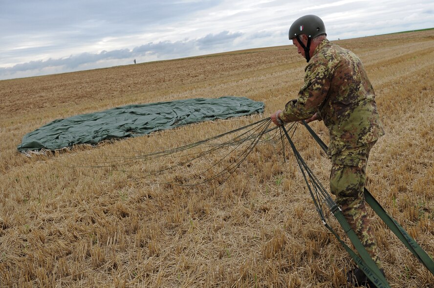 Italian Army soldier Giovanni Cacciari, Italian Airborne, packs his parachute after landing at Bunker drop zone in southwestern, Germany on Aug. 13, 2009. U.S. soldiers and Airmen did a combined airborne drop with four other NATO countries. German, Italian, Belgium, and Dutch Armies attended the airborne drop officially called International Jump Week. (U.S. Air Force photo by Airman 1st Class Grovert Fuentes-Contreras)(Released) 