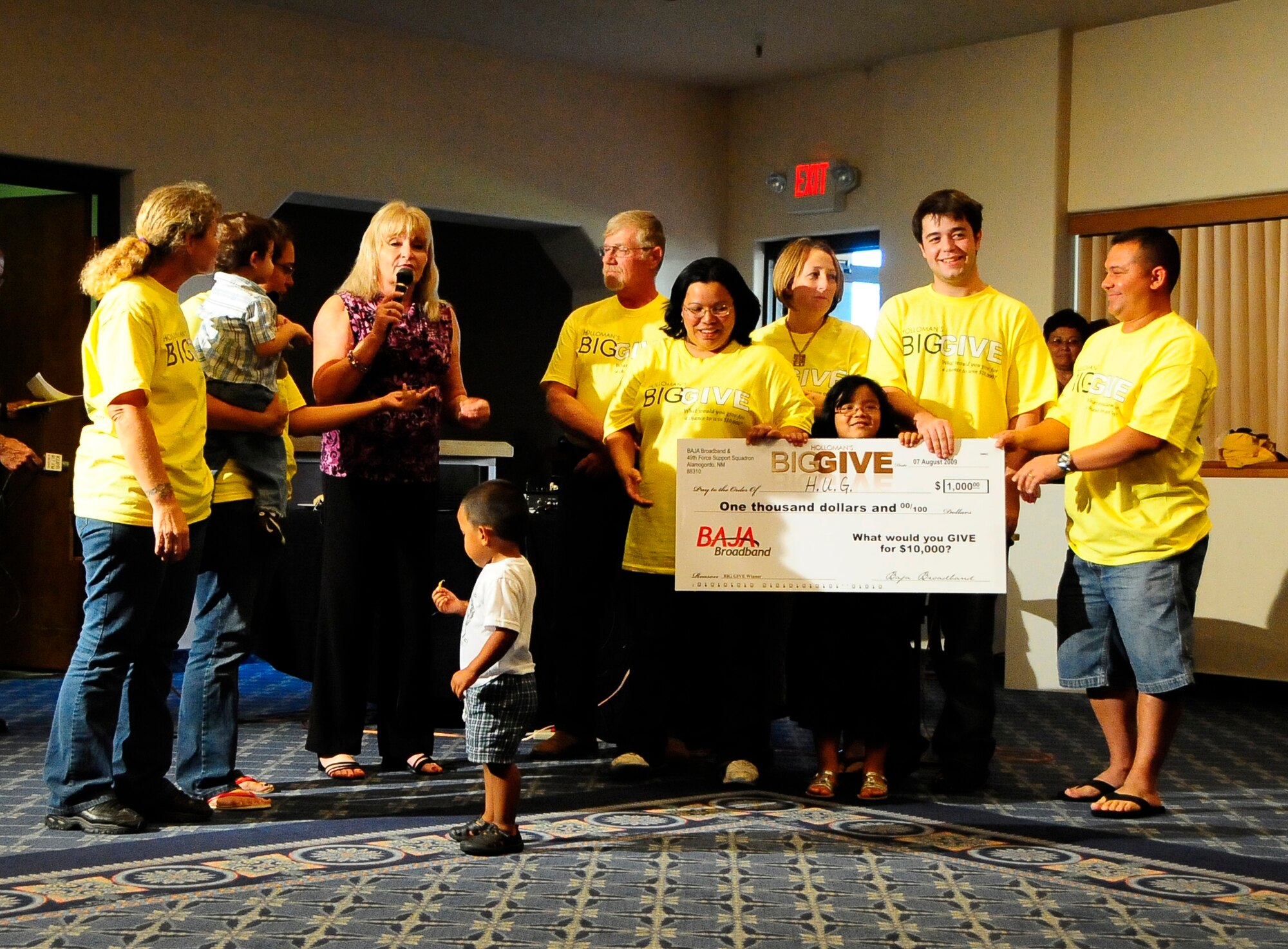 HOLLOMAN AIR FORCE BASE, N.M. -- Team H.U.G. (Holloman Underground Group) is presented with a $1,000 reward on behalf of Baja Broadband at the Big Give after-party here Aug. 7. H.U.G. advocated for the Children, Youth and Family Department as well as making more than 40 backpacks full of personal items to give to children. They also underwent clean-up projects and renovations on three homes for those in need, including a sober living house. (U.S. Air Force photo by Tech. Sgt. Chris Flahive)