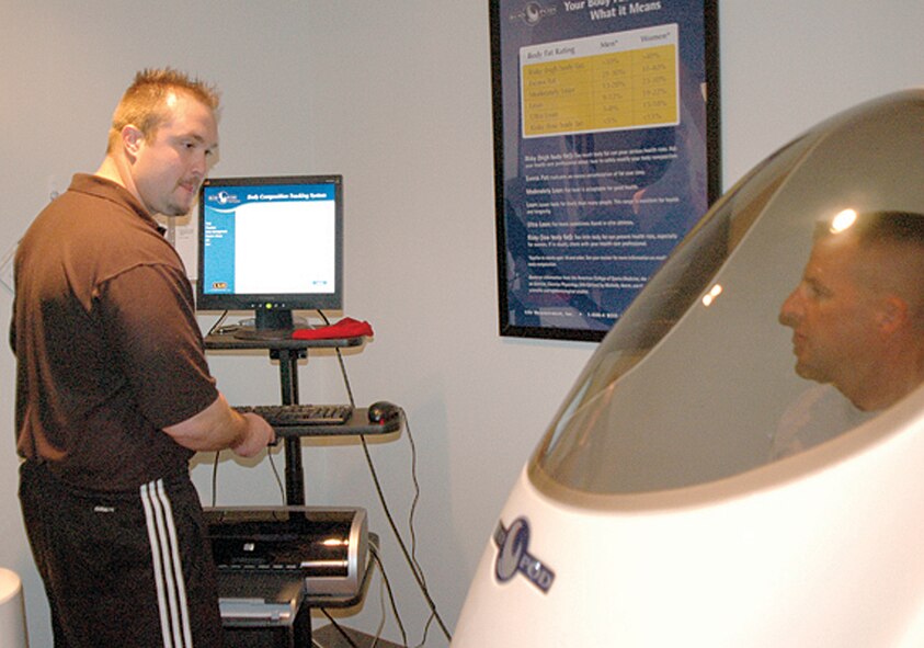 Col. Patrick Higby, 75th Air Base Wing commander, takes a body composition test in the Bod Pod at the Health and Wellness Center as Ryan Burns, 75th Aerospace Medicine Squadron exercise physiologist, records the results.