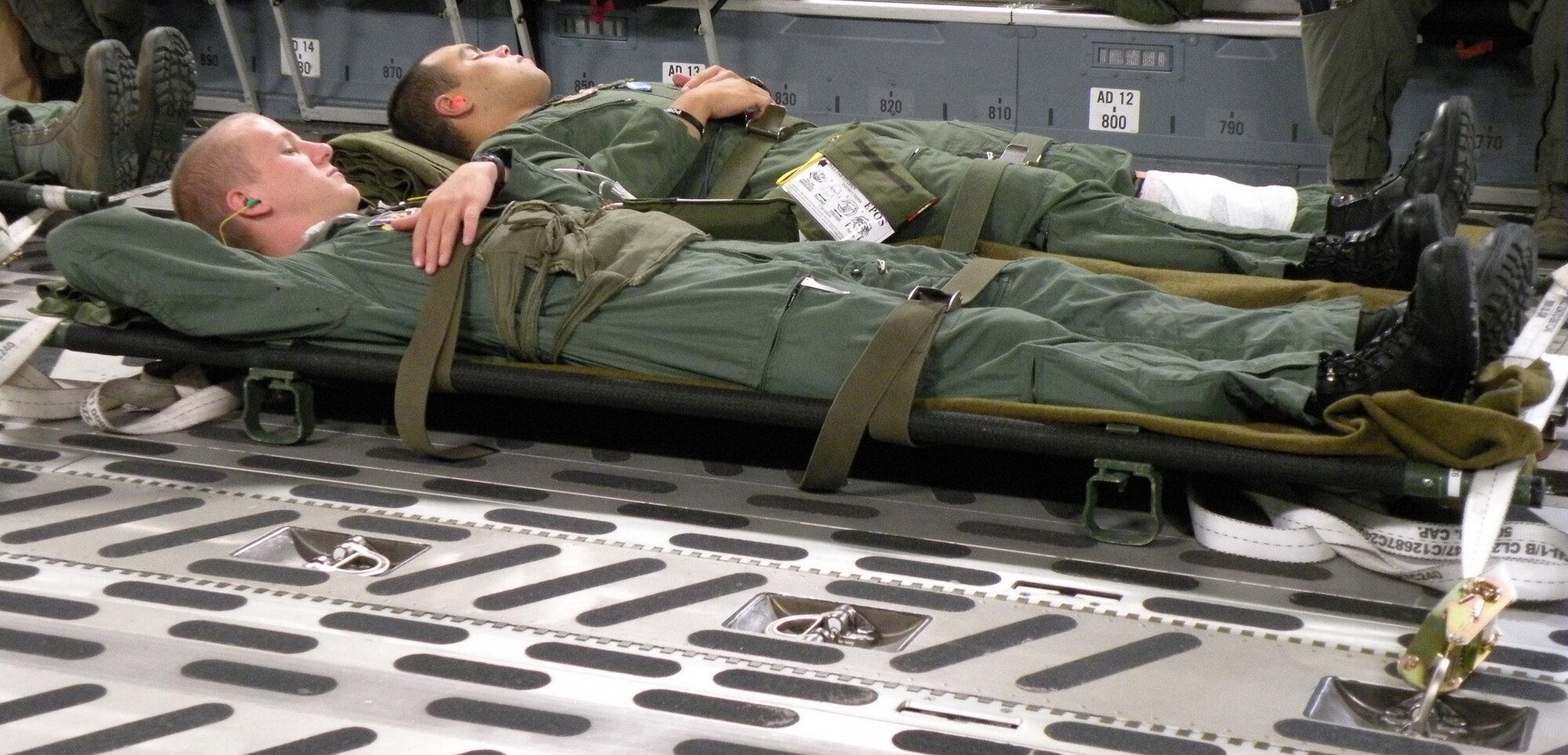 WRIGHT-PATTERSON AIR FORCE BASE, Ohio – Airman 1st Class Nickolas Richards, far left, and Senior Airman Eddie Mulkey, 445th Aeromedical Evacuation Squadron medical technicians, simulate being patients on a training mission aboard a C-17 Globemaster III during Dissimilar Aircraft Refresher Training Aug. 8.  The AES crew from the 934th AES, Minneapolis-St. Paul Air Reserve Station, was monitoring the simulated ambulatory patients after loading them onto the aircraft. (U. S. Air Force photo/2nd Lt. Katie Spellman)