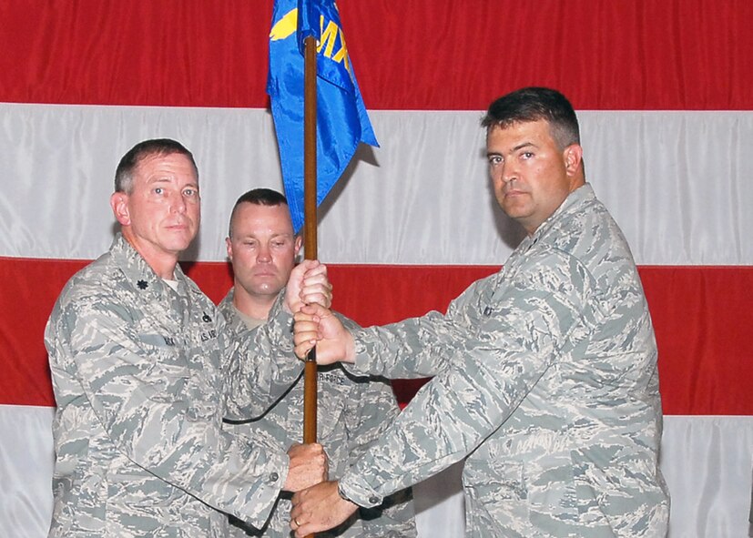 Capt. Kirby Findley accepts the 131st Maintenance Squadron flag from Lt. Col. Mark Beck, 131st Maintenance Group commander, during the 131st BW Assumption of Commands ceremony held Aug. 8, at the Army National Guard Armory, Whiteman Air Force Base, Mo. (U.S. Air Force Photo by Master Sgt. Mary-Dale Amison)