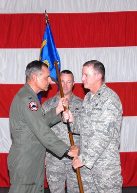 Lt. Col. Mark Beck accepts the 131st Maintenance Group flag from Col. Robert L. Leeker, 131st BW commander, during the 131st BW Assumption of Commands ceremony held Aug. 8, at the Army National Guard Armory, Whiteman Air Force Base, Mo. (U.S. Air Force Photo by Master Sgt. Mary-Dale Amison)