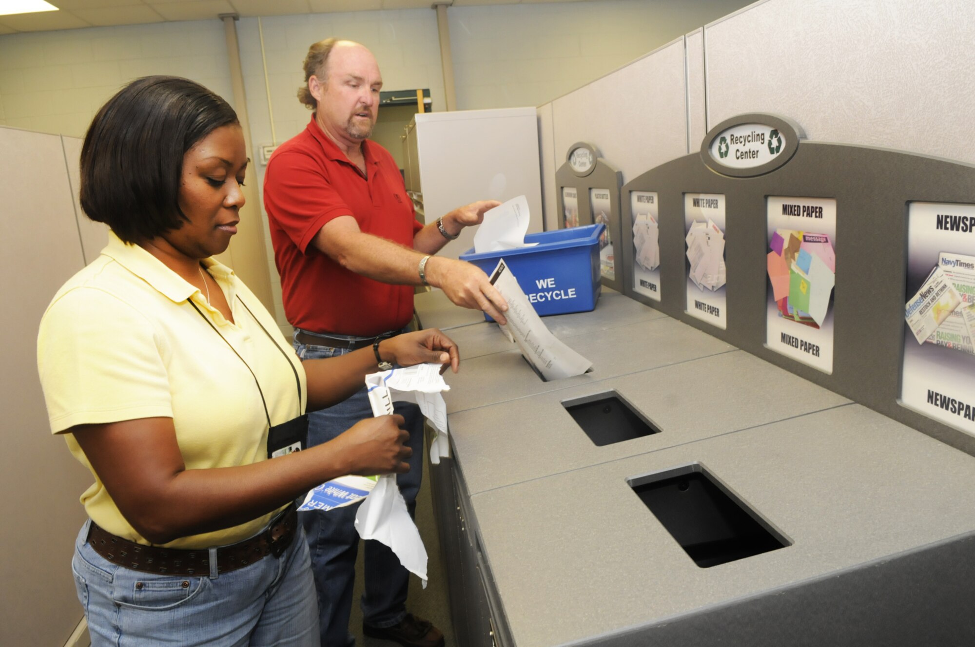 Ervanette Murry and Ken Wharam  place used paper in the appropriate containers of the recycling center in building 359. U. S. Air Force photo by Sue Sapp