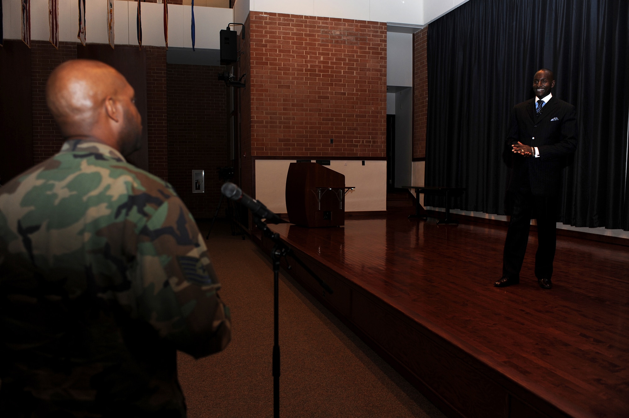 Dr. Randal Pinkett answers a question from Technical Sgt. Kendrick Ross, Community College of the Air Force affiliated schools liaison, after 45 minutes of motivational remarks to the crowd assembled in Grace Peterson Hall Aug. 12 at the U.S. Air Force Expeditionary Center on the Fort Dix section of Joint Base McGuire-Dix-Lakehurst, N.J.  Dr. Pinkett, an entrepreneur, author, Rhodes scholar and winner of the Season 4 reality show, The Apprentice, was the third in a series of professional development speakers helping the Center celebrate its 15th Anniversary. (U.S. Air Force Photo/Staff Sgt. Nathan G. Bevier) 