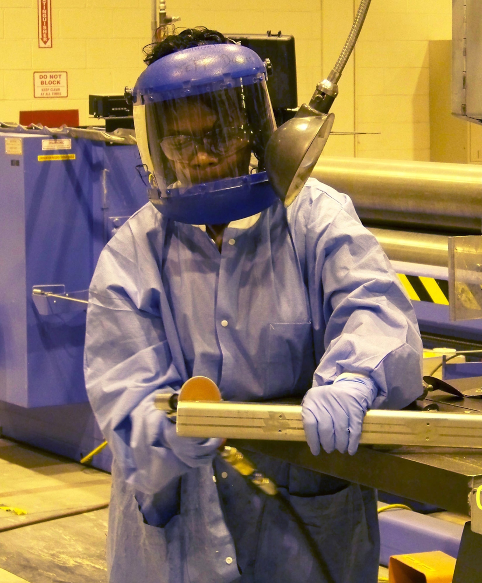 Veronica Thomas, a sheet metal mechanic, de-burrs an inconel steel part for installation on the C-130 IRSS. U. S. Air Force photo by Chad Langston
