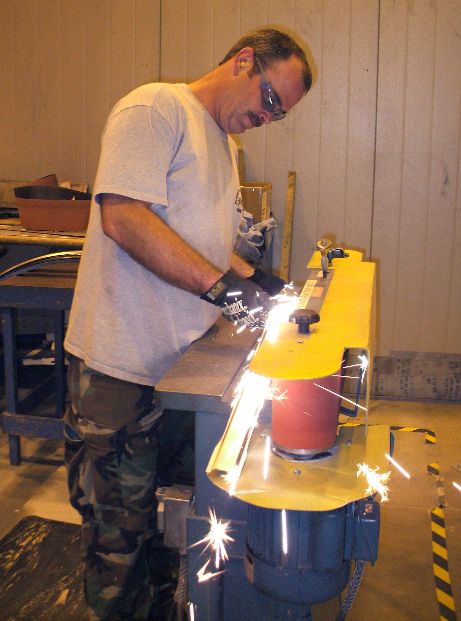 David Stroupe, a sheet metal mechanic, grinds an inconel steel part to the required dimensions for the C-130 IRSS. U. S. Air Force photo by Dave Hoffman
