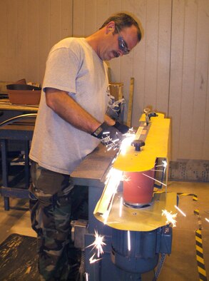 David Stroupe, a sheet metal mechanic, grinds an inconel steel part to the required dimensions for the C-130 IRSS. U. S. Air Force photo by Dave Hoffman