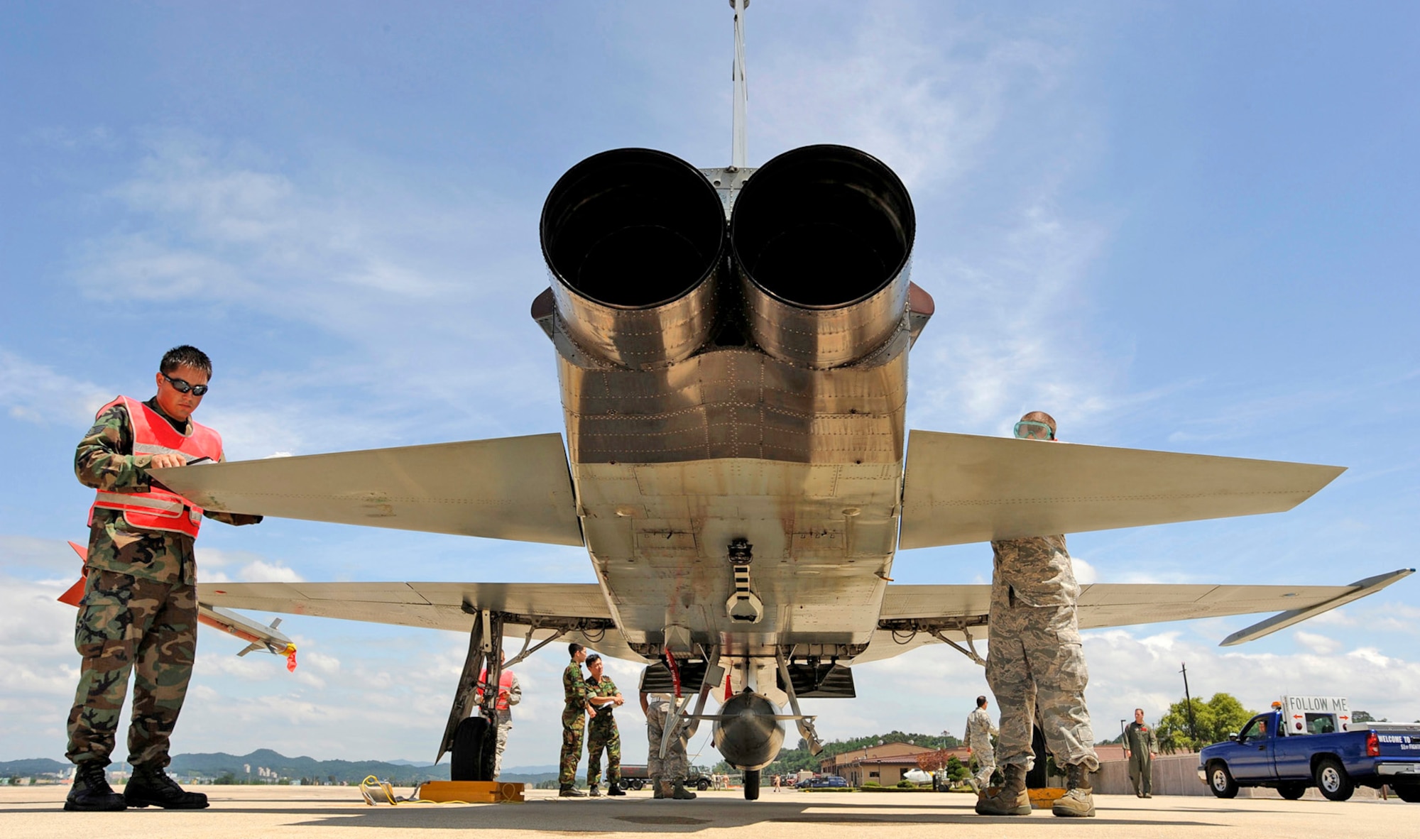 Staff Sgts. James Hohlt (left) and Trenton Schreyer recover an F-5 Tiger II Aug. 10 at Osan Air Base, South Korea. They are servicing the F-5 as part of the Osan AB combat cross-servicing program. The program is a mutual agreement between the U.S. and South Korean air forces that allows the maintainers from both services to get hands-on experience working on each other's aircraft. (U.S. Air Force photo/Staff Sgt. Brian Ferguson)
