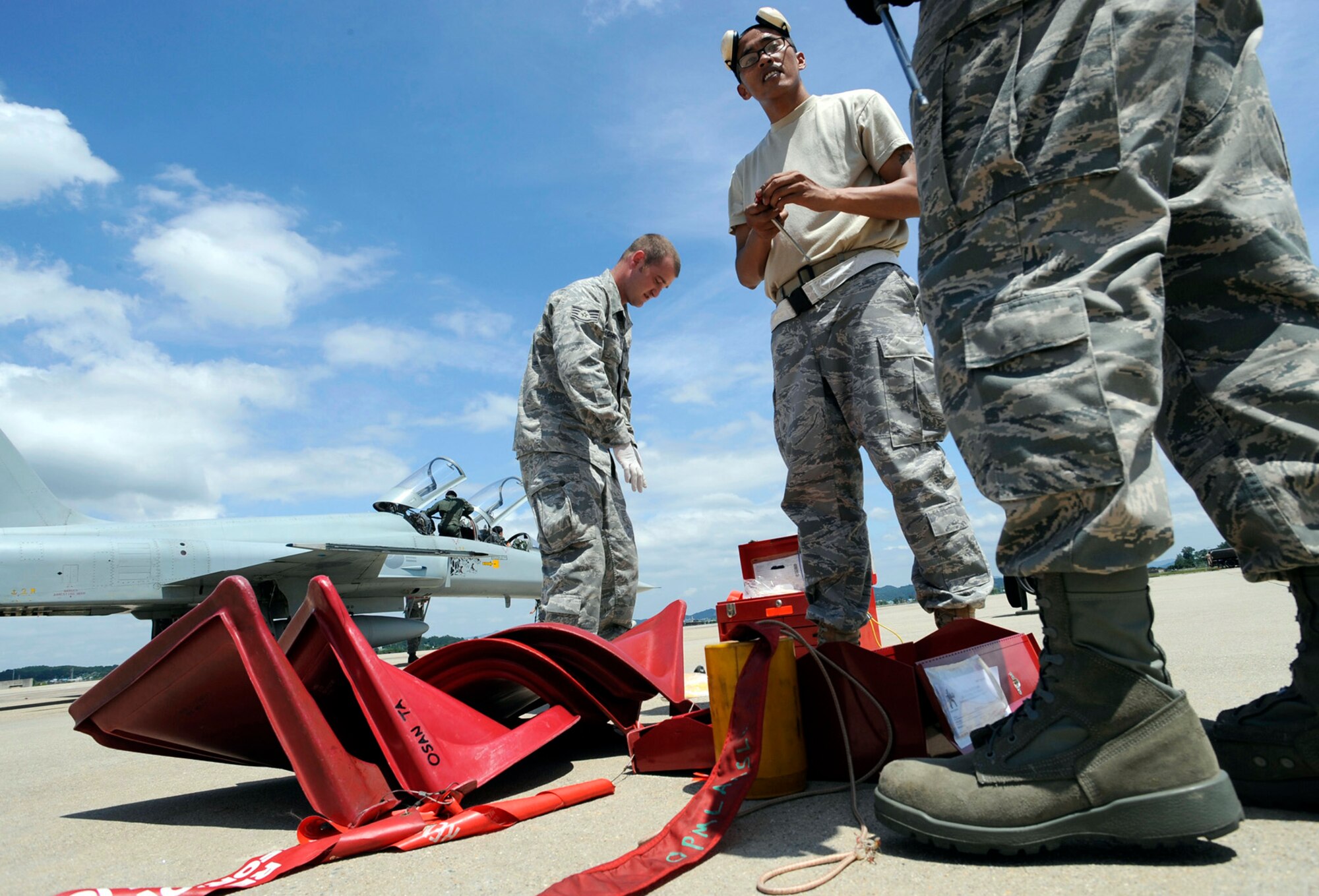 Maintenance and weapons Airmen from the 51st Fighter Wing prepare to service two F-5 Tiger IIs Aug. 10 at Osan Air Base, South Korea. They are servicing the F-5s as part of the Osan AB combat cross-servicing program. The program is a mutual agreement between the U.S. and South Korean air forces that allows the maintainers from both services to get hands-on experience working on each other's aircraft. (U.S. Air Force photo/Staff Sgt. Brian Ferguson)