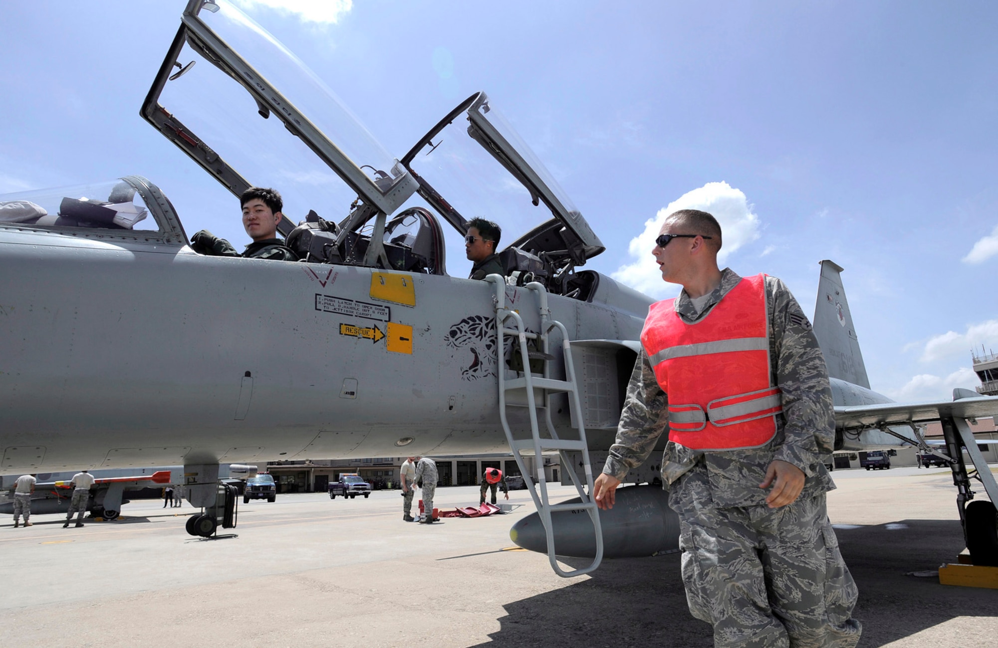 Senior Airman Sean Rindfleisch looks on as two South Korean air force pilots prepare to exit an F-5 Tiger II Aug. 10 at Osan Air Base, South Korea. Airman Rindfleisch is servicing the F-5 as part of the Osan AB combat cross-servicing program. The program is a mutual agreement between the U.S. and South Korea that allows the maintainers from both services to get hands-on experience working on each other's aircraft.(U.S. Air Force photo/Staff Sgt. Brian Ferguson)