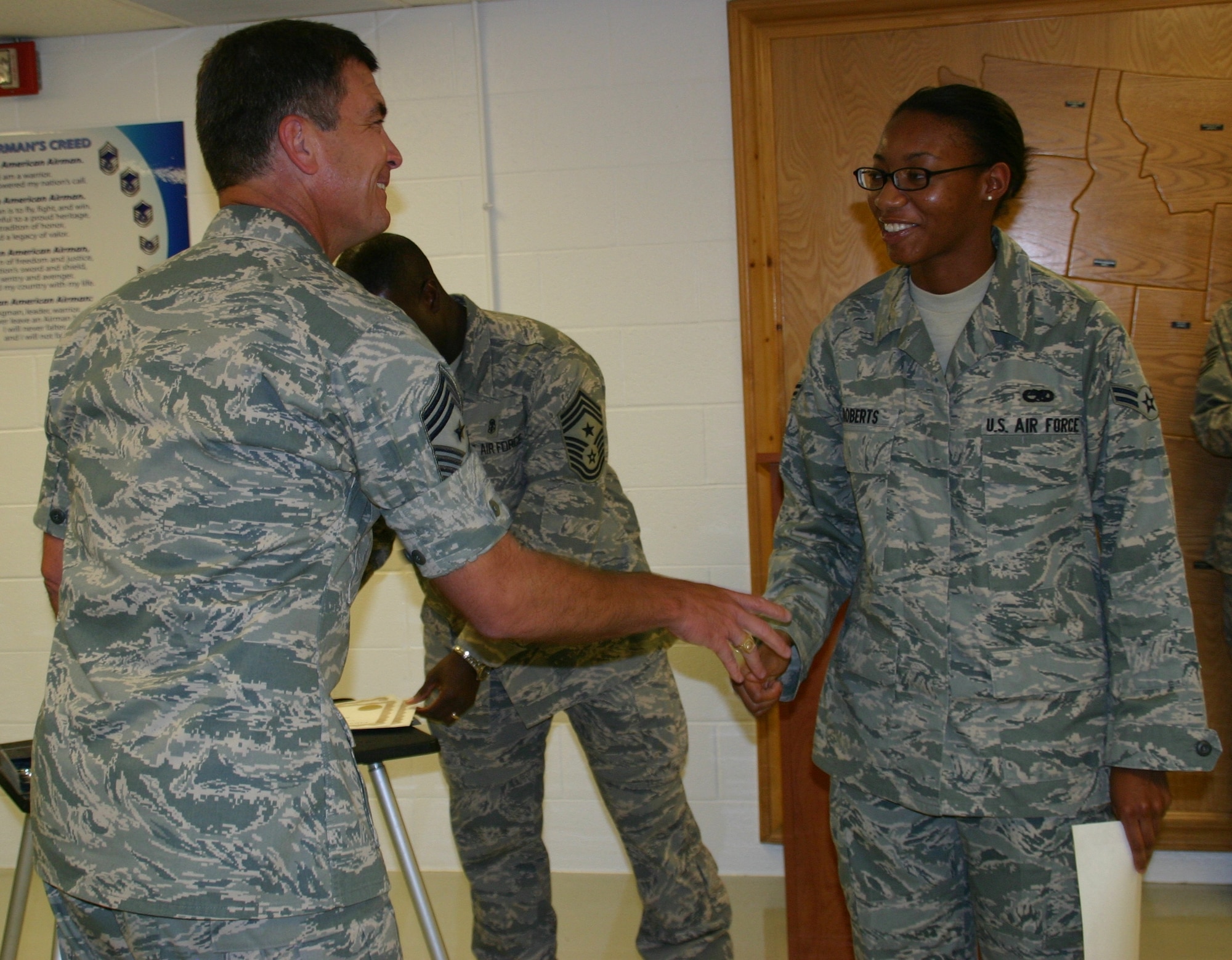 Chief Master Sgt. James Foltz, former command chief, 552 ACW, congratulates one of the latest graduates at the First Term Airman Center. Photo courtesy of 1st Lt. Kinder Blacke.