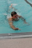 Senior Airman Joseph Jurotich participates in a six-man swimming relay race during the Commander's Challenge at the base pool Aug. 7. Airman Jurotich had to swim a lap before his teammate could enter the water. Airman Jurotich is a member of the 437th Civil Engineer Squadron.