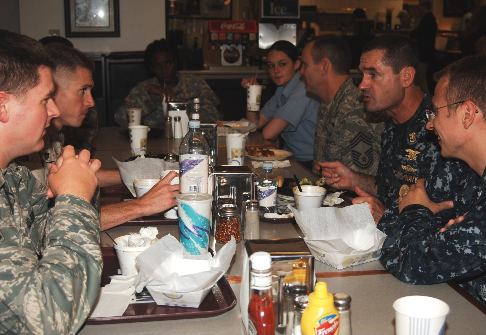 Fleet Master Chief Roy M. Maddocks, Jr. enjoys lunch with servicemembers at the "NYPD Deli" eatery on Royal Air Force Molesworth during his August 12th visit to the base.  The U.S. European Command Senior Enlisted Leader was accompanied to RAF Molesworth by Air Force Chief Master Sgt. Allyn W. Webb, (on his right) SEL for the EUCOM Director of Intelligence.  (U.S. Air Force photo by Staff Sgt. Rachel A. Goff)