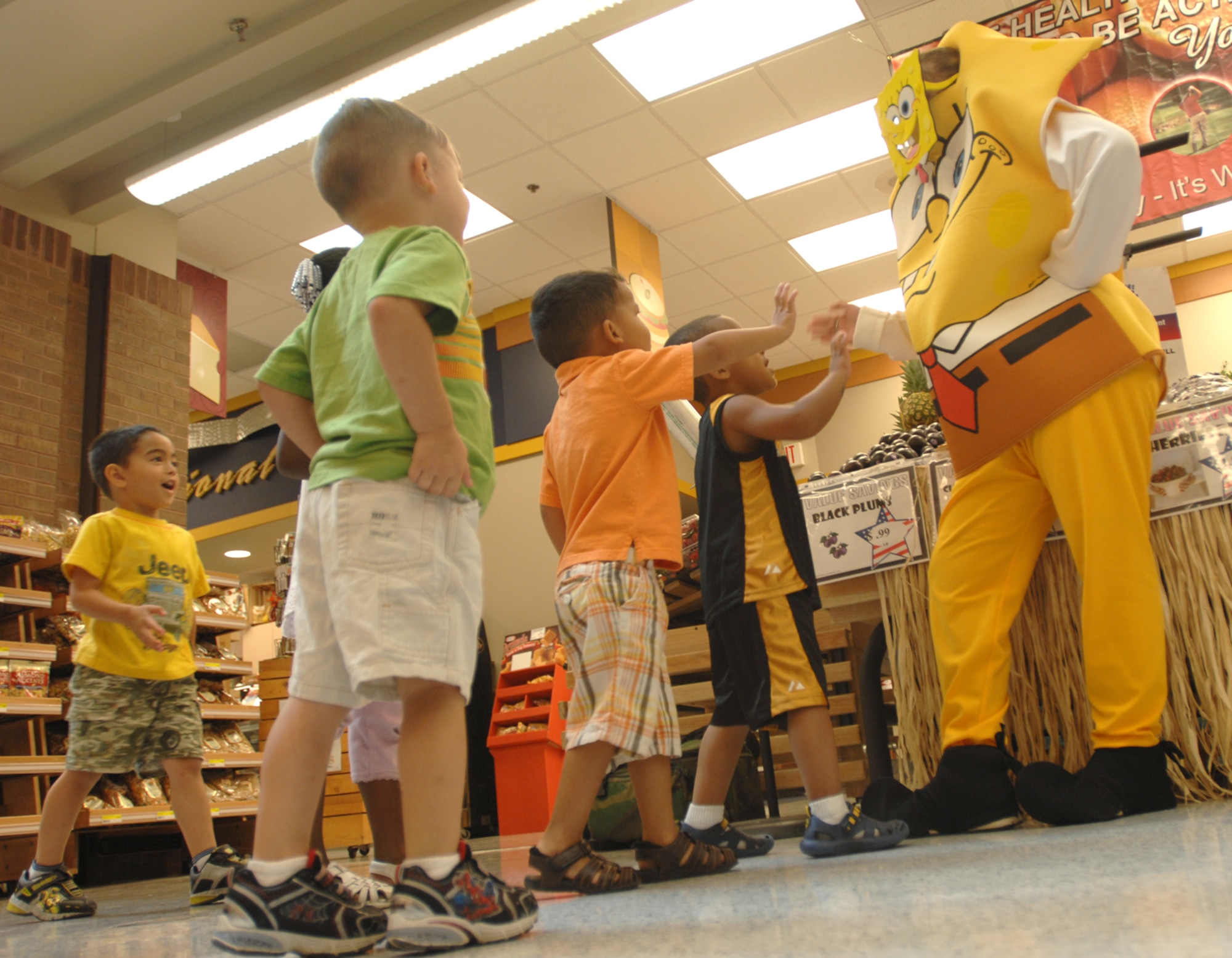 WHITEMAN AIR FORCE BASE, Mo. - The Whiteman Commissary played host to the Child Development Center’s preschool class four and Spongebob Squarepants, Aug. 5. While at the Commissary the children and Sharon Greene, produce manager, played ‘name that fruit.’ Alyne Frampton, a commissary employee, also assisted Ms. Greene and the children through the coolers and stock room. Spongebob was on hand for photos with Karen Howard and Janelle Bratton, CDC teachers and the children. C & C Produce of Kansas City, Mo donated oranges to the children as parting gifts. (U.S. Air Force photo/Senior Airman Kenny Holston)