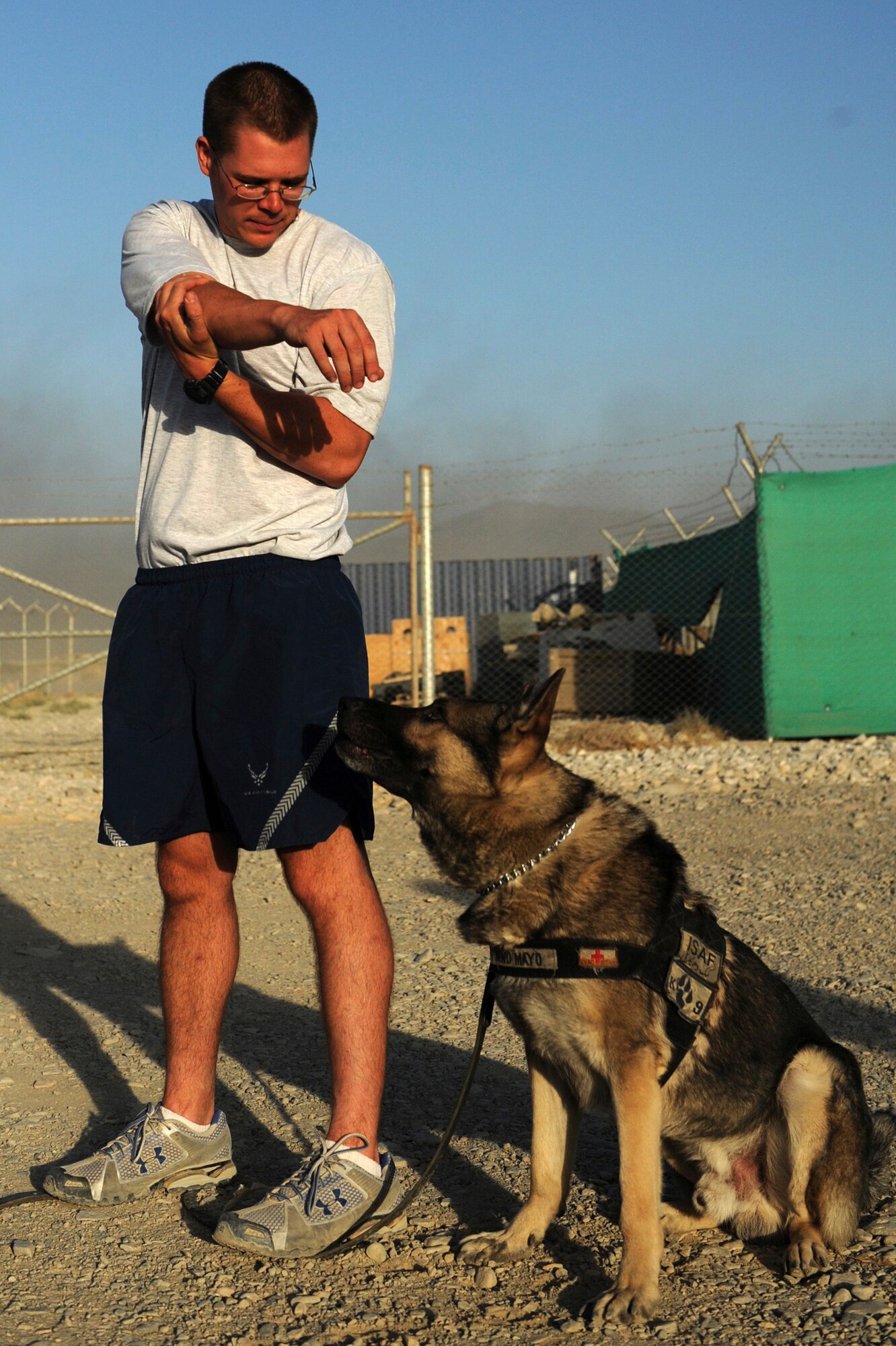 BAGRAM AIRFIELD, Afghanistan - Staff Sgt. Justin Kitts stretches with his German shepherd, Mayo, Aug. 9. Sergeant Kitts an eight-year Air Force veteran, is a dog handler with the 455th Expeditionary Security Forces Squadron and is deployed from Luke Air Force Base, Ariz. He and his dog patrol the base and inspect mail, luggage, and vehicles for narcotics. (U.S. Air Force photo/Staff Sgt. J.G. Buzanowski)