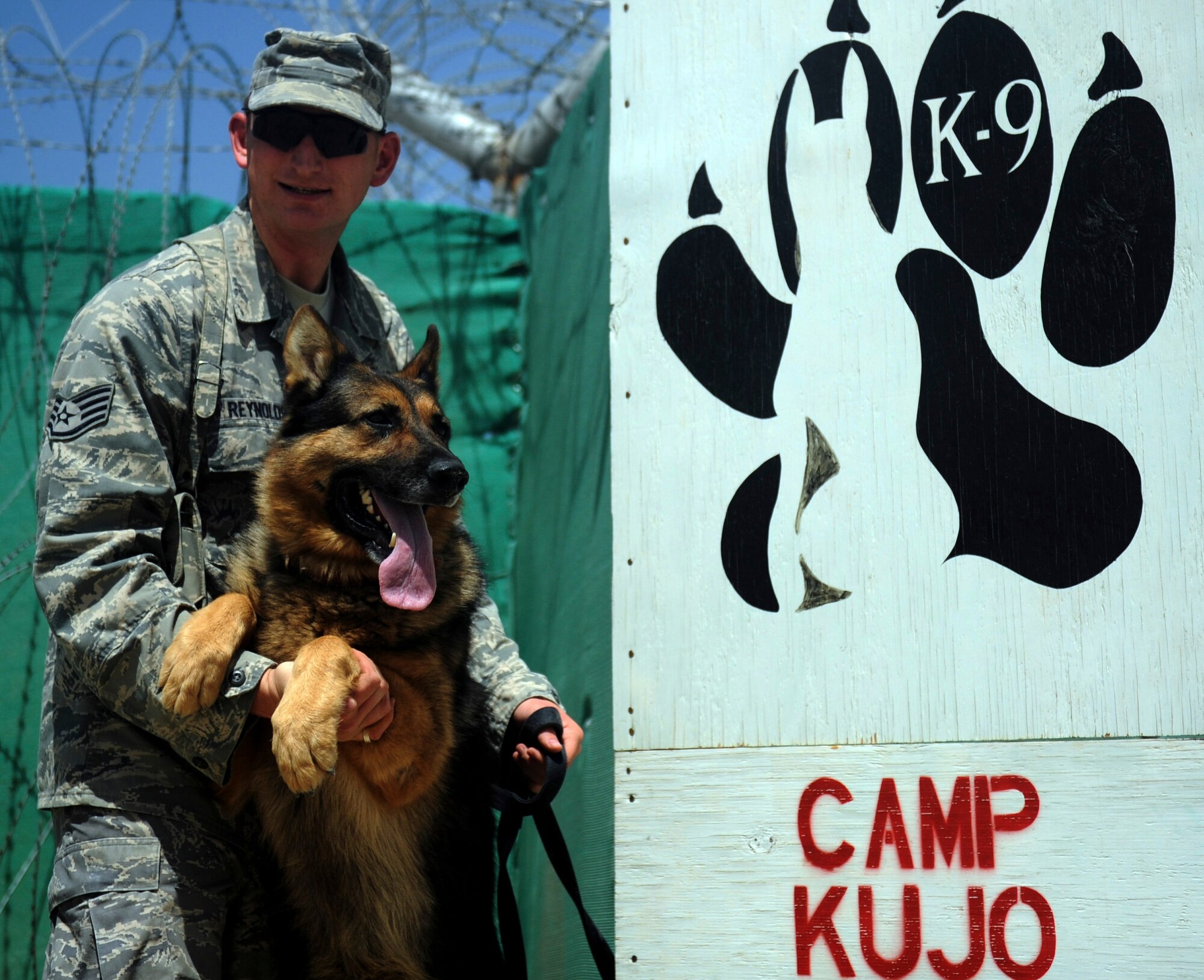BAGRAM AIRFIELD, Afghanistan - Staff Sgt. Chris Reynolds poses with his German shepherd, Baiky, Aug. 7. Sergeant Reynolds, an eight-year Air Force veteran, is a dog handler with the 455th Expeditionary Security Forces Squadron and is deployed from Vandenberg Air Force Base, Calif. He and his dog patrol the base and inspect mail, luggage, and vehicles for narcotics. (U.S. Air Force photo/Staff Sgt. J.G. Buzanowski)