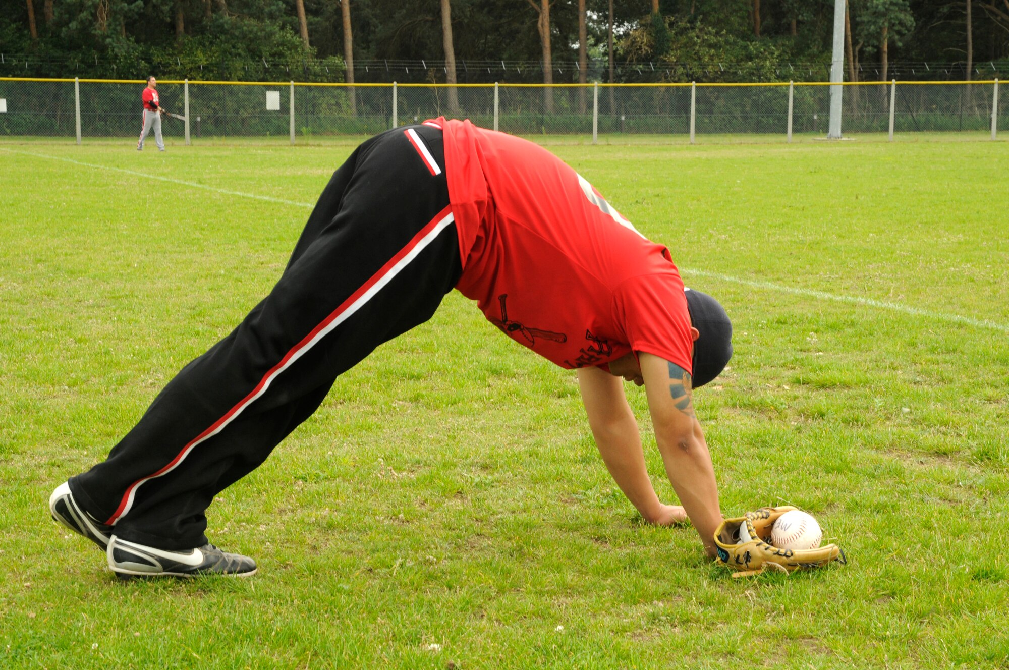 Edgar Pardo of the 48th Munitions Squadron’s Arms Shop stretches his calf before the intramural softball championship game against the 48th Medical Group’s Med Dawgs on August 6, 2009, at RAF Lakenheath, England. The Med Dawgs took home the victory after winning the second of two games against the Arms Shop. The final score was 14 to 11. (U.S. Air Force photo/Airman 1st Class Eboni Knox)