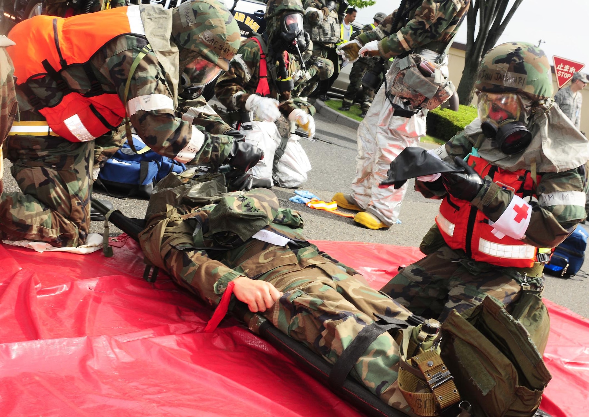 YOKOTA AIR BASE, Japan -- Staff Sgt. Nathan Mainer puts a gas mask on a patient and Airmen First Class Ivan Jeremiah puts on gloves following a simulated mortar attack, Aug 13, during Phase II Exercise Beverly Morning 09-06. (U.S. Air Force photo/Airman First Class Devin Doskey)