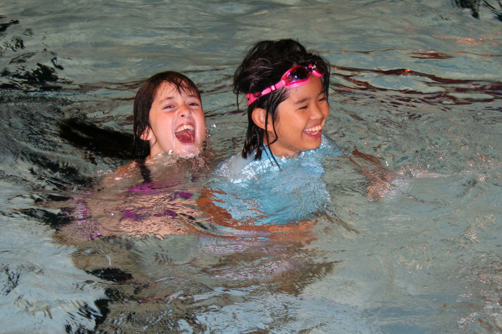 Teri Stewart and Hinako Itokazu enjoy a swim at the pool during the International Youth Lock-in held at the Kadena Youth Center August 8. The children spent the night playing games, sampling American and Japanese cuisine and making new friends.   (Courtesy photo)       
