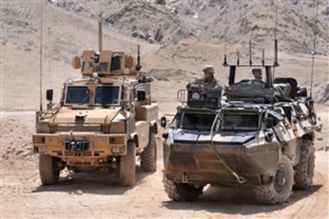 A U.S. mine resistant ambush protected vehicle and a French tactical armored vehicle bring troops back from a mission in Shpee valley to Combat Outpost Belda in Kapisa province, Afghanistan, Aug. 7, 2009. The mission was part of a three-day operation involving Afghan,  French and coalition forces.