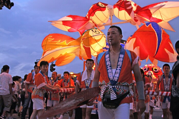 A festival particpant clears the congested streets to make room for the oncoming parade at the annual Goldfish Lantern Festival in Yanai Aug.13. The festival is an annual event that includes a variety of food and activities for the crowd to enjoy. As night fell and the goldfish lanterns illuminated the streets, the throng of people eagerly awaited the fireworks planned at the end of the festival.