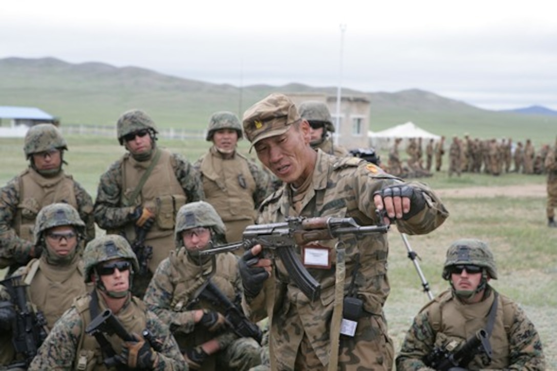 A Mongolian Armed Forces officer teaches U.S. Marines from 1st Platoon, Company E, 3rd Assault Amphibious Battalion, 1st Marine Division about the AK-47 Assault rifle at the Five Hills Training Area as part of Khaan Quest 2009 in Mongolia on Aug. 14. The Marines and Mongolians exchanged knowledge about their respective weapon systems. (Official U.S. Marine Corps photo by Lance Cpl. Nathan McCord)