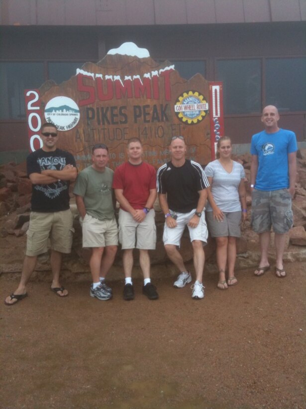 (From left to right) Marine Corps Communications-Electronics School instructors Sgt. Christopher Apodaca, Master Sgt. Robert Mielish, Sgt. Jack Linke, Staff Sgt. James Haunty, Staff Sgt. Kristy Franco, and Sgt. Justin Lucker, stand in front of Pikes Peak Summit sign in Colorado Aug. 14. The six Marines had been training since April in preparation for this 13.3 mile trek.
