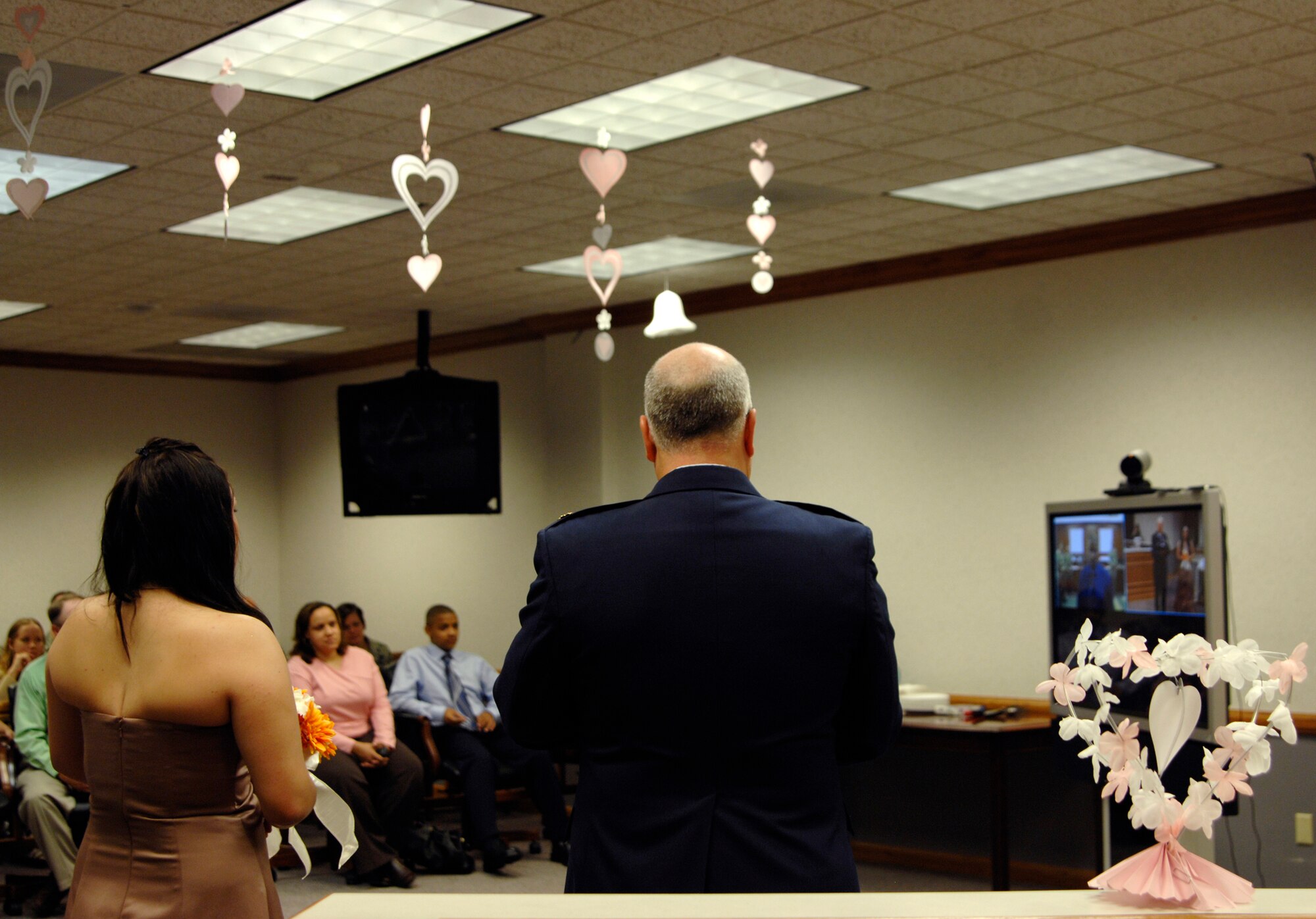 Senior Airman TaNeil Toman, 22nd Logistics Readiness Squadron,  stands next to Chaplain Maj. Boyd Short, at McConnell Air Force Base, and prepares to say “I do” in front of loved ones during her video teleconference wedding, Aug. 7. Chaplain Short married Airman Toman to Tech. Sgt. Carlos Reyes Jr., 728th Aircraft Maintenance Squadron, Incirlik Air Base, Turkey. The VTC wedding was a McConnell first. (U.S. Air Force photo/Senior Airman Laura Suttles)