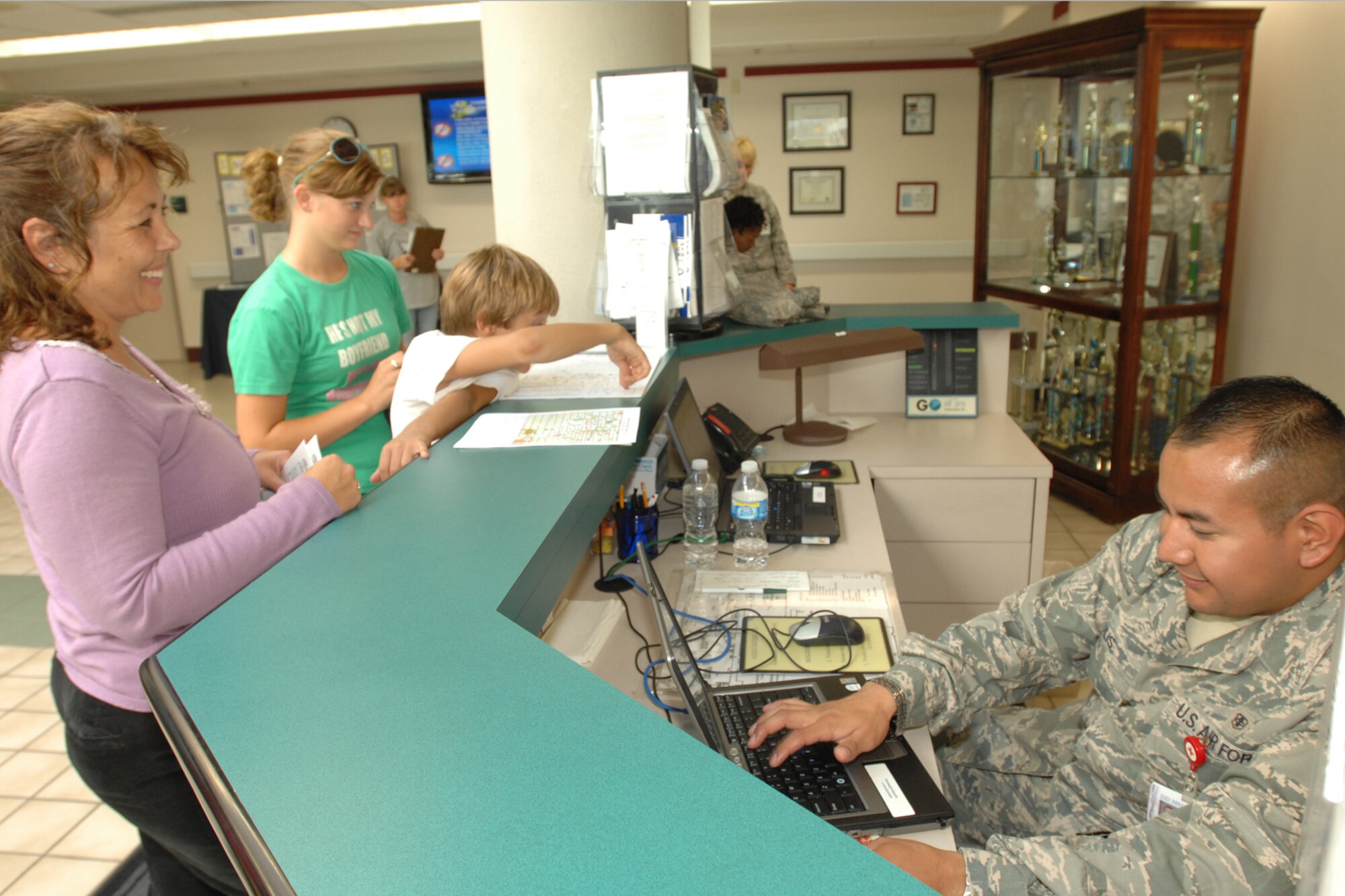 Senior Airman Victor Solis, 22nd Medical Operations Squadron, schedules Rachel, 17, and Josh, 10, Holman for their sports physical on Aug 5. Josh and Rachel are the son and daughter of Beth Holman, 22nd Contracting Squadron, and Steve Holman, 22nd Force Support Squadron. The 22nd Medical Group offers sports physicals at the beginning and the end of the summer prior to the start of the school year. (U.S. Air Force photo/Staff Sergeant Jamie Train)