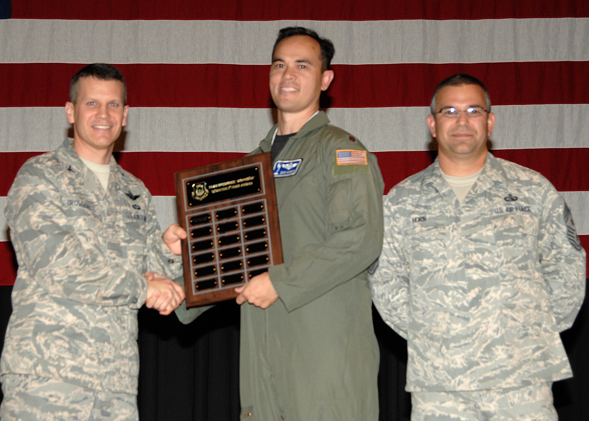 Maj. Dan Haman, 22nd Air Refueling Wing plans and programs officer, receives an award from Col. Jamie W. Crowhurst, 22nd Air Refueling Wing commander, and Chief Master Sgt. Timothy Horn, 22nd Air Refueling Wing command chief, on McConnell Air Force Base, Kan., Aug. 7.  Plans and Programs earned the Quarterly Wing Team Award for efficient work. (U.S. Air Force photo/Senior Airman Laura Suttles)