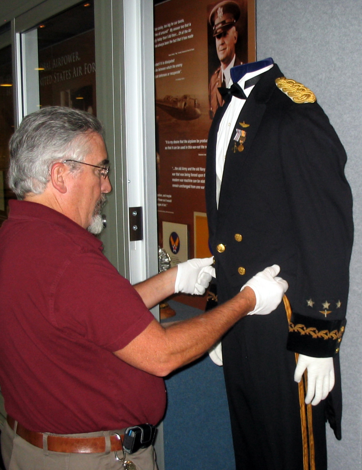 Paul Martin adjusts the tail coat on General Henry "Hap" Arnold's formal evening dress uniform in the recently completed Arnold Hall exhibit at the U.S. Air Force Academy in Colorado Springs, Colo., Aug. 11, 2009. Mr. Martin is a museum specialist and the curator of collections for the Academy. (U.S. Air Force photo/Ken Carter)