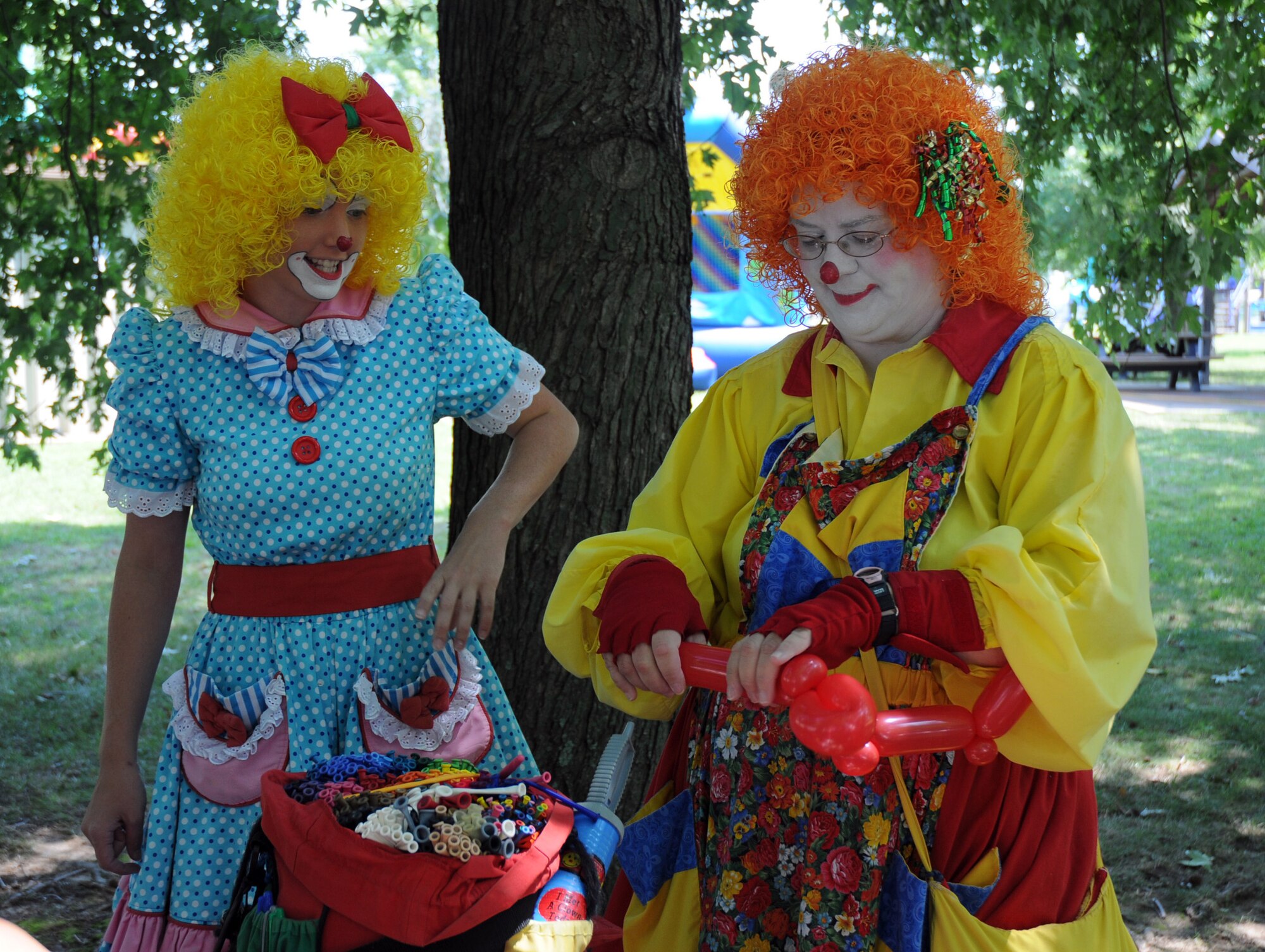 Snippy Doodles, right, and Tiddles make balloons during their magic show at the Eagle's Nest picnic area Aug. 1 as part of the 512th Airlift Wing's bi-annual picnic.  (U.S. Air Force photo/Capt. Marnee A.C. Losurdo)