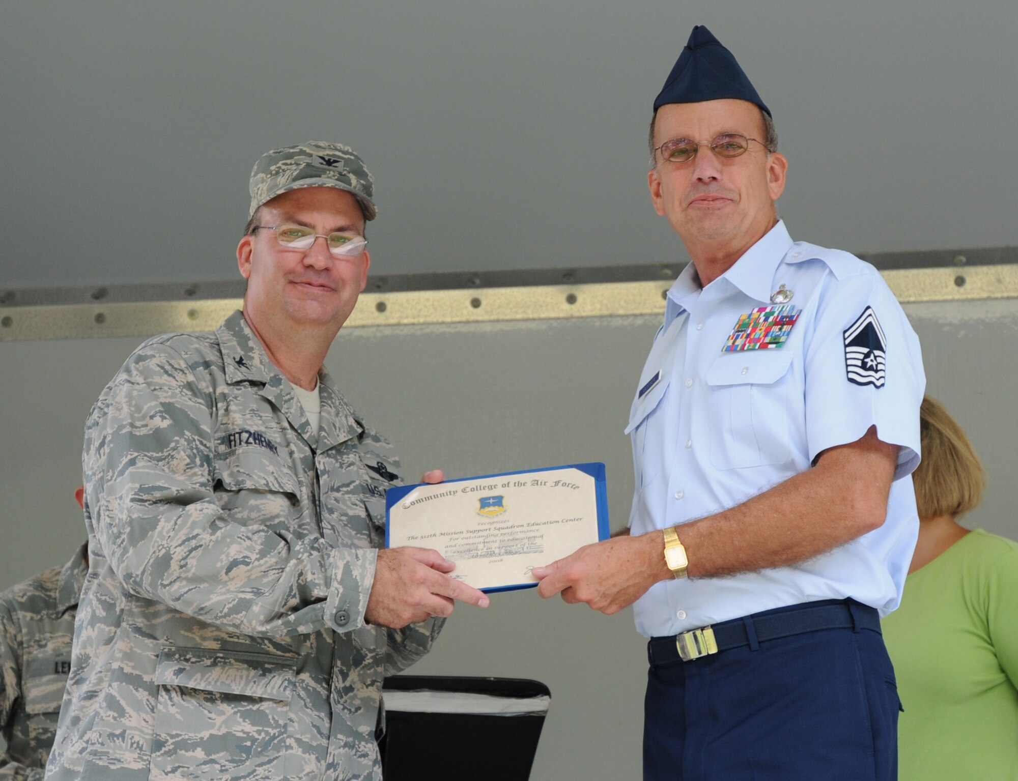 Col. Michael T. Fitzhenry, 512th Airlift Wing vice commander, presents Senior Master Sgt. Randall Anderson, chief of 512th Education and Training, with a certificate of recognition during the commanders call Aug. 1 here. Sergeant Anderson was recognized for outstanding achievement for exceeding the Air Force Reserve Command average of 2.4 percent in 2008 for the number of enlisted wing members receiving the Community College of the Air Force associates degree in applied science.  The wing's graduation average was 4.7 percent. (U.S. Air Force photo/Capt. Marnee A.C. Losurdo)