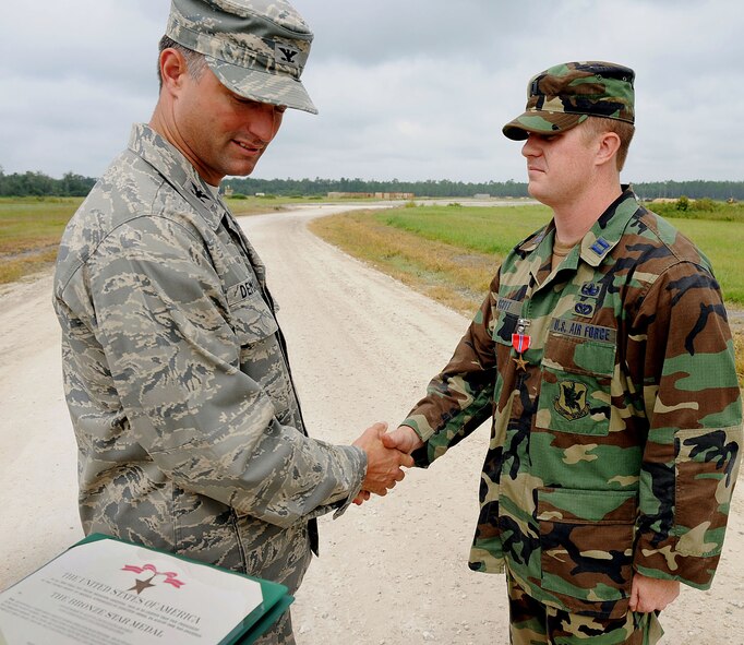 MOODY AIR FORCE BASE, Ga. -- Col. William DeMaso, 23rd Wing vice commander, presents Capt. Robert Scott, 23rd Civil Engineering Squadron Explosive Ordnance Disposal flight commander, with a Bronze Star Medal during an award ceremony here Aug. 14. Captain Scott was awarded the medal for his service during a deployment from November 2007 to May 2008 in support of Operation Iraqi Freedom. (U.S. Air Force photo by Airman 1st Class Joshua Green)