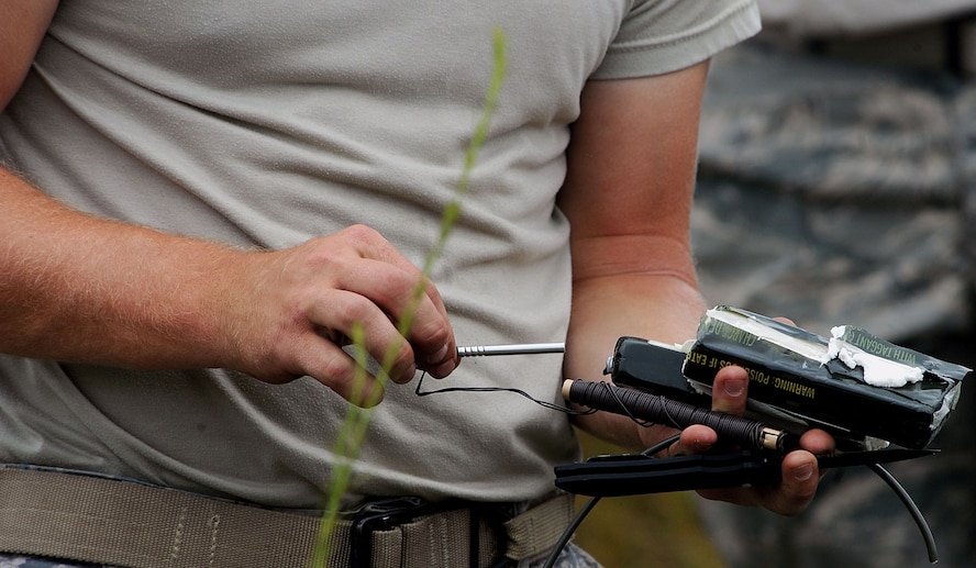 MOODY AIR FORCE BASE, Ga. -- An Airmen from the 23rd Civil Engineer Squadron Explosive Ordnance Disposal team rigs a military high-explosive in preparation for detonation during a Bronze Star Medal award ceremony here Aug. 14. (U.S. Air Force photo by Airman 1st Class Joshua Green)