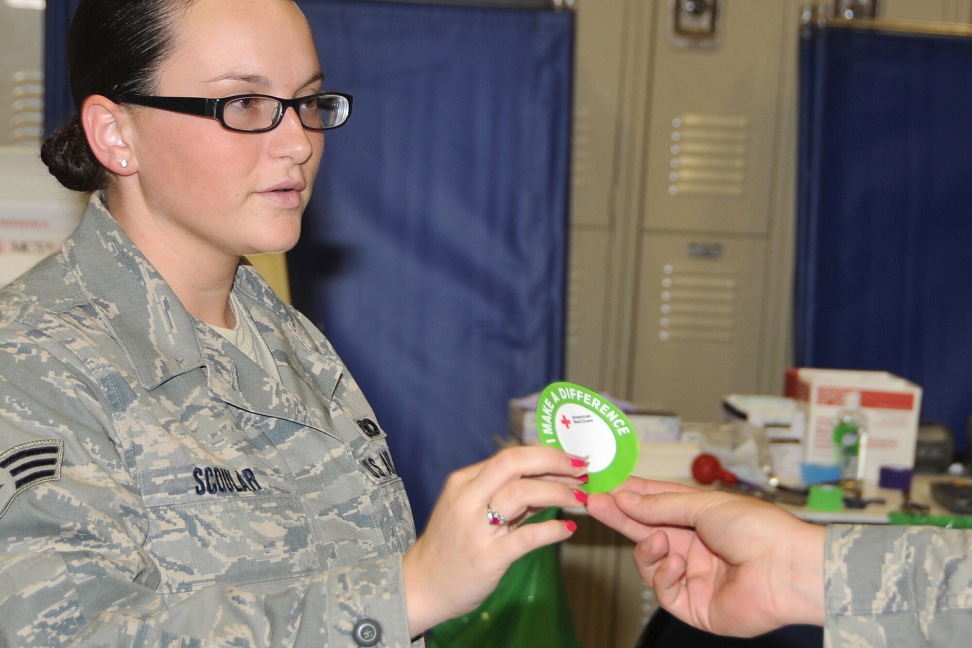 OFFUTT AIR FORCE BASE, Neb. - Senior Airman Jessica Scoular, an armorer from the Security Forces Squadron, recieves a sticker for donating blood during the American Red Cross Blood Drive at the SFS Guardmount room Aug. 12. U.S. Air Force Photo by Jeff W. Gates.