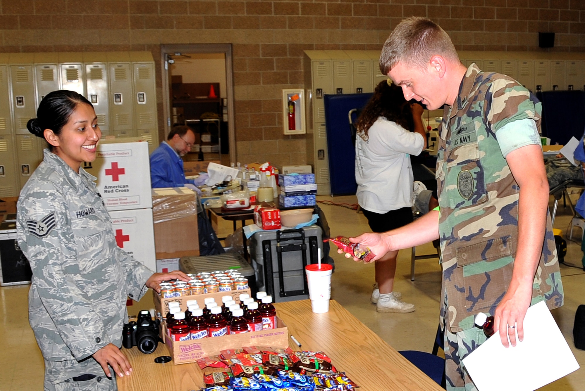 OFFUTT AIR FORCE BASE, Neb.- Staff Sgt. Tracy Howard, a combat arms specialist with the 55th Security Forces Squadron, offers a snack to Navy Petty Officer 2nd Class Jeremy Spain, a master-at-arms specialist from the Security Forces Squadron, after he donated blood at the American Red Cross Blood Drive at the SFS Guardmount room here, Aug. 12. U.S. Air Force Photo by Jeff W. Gates.