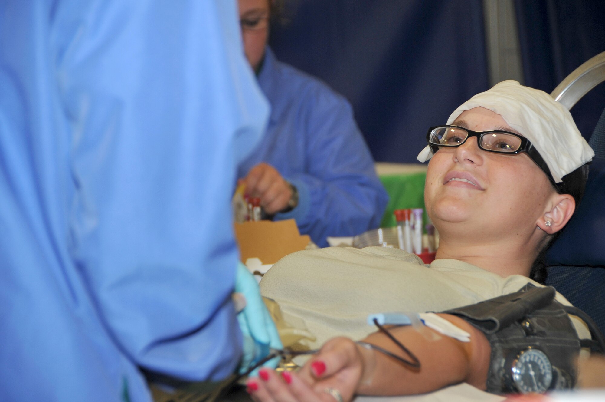 OFFUTT AIR FORCE BASE, Neb. - Senior Airman Jessica Scoular, an armorer from the Security Forces Squadron, smiles as she is told she's finished giving blood during the American Red Cross Blood Drive at the SFS Guardmount room, Aug. 12. U.S. Air Force Photo by Jeff W. Gates.