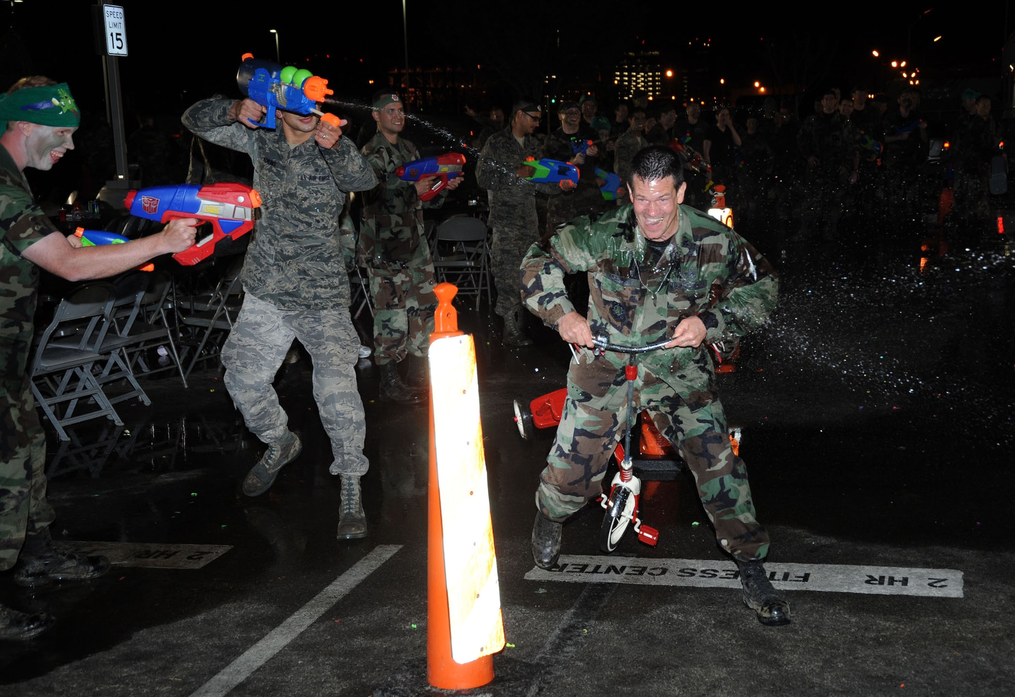An unidentified Airman pedals through a spray of water guns during the SMC Combat Dining In, Aug. 7.  (Photo by Lou Hernandez)