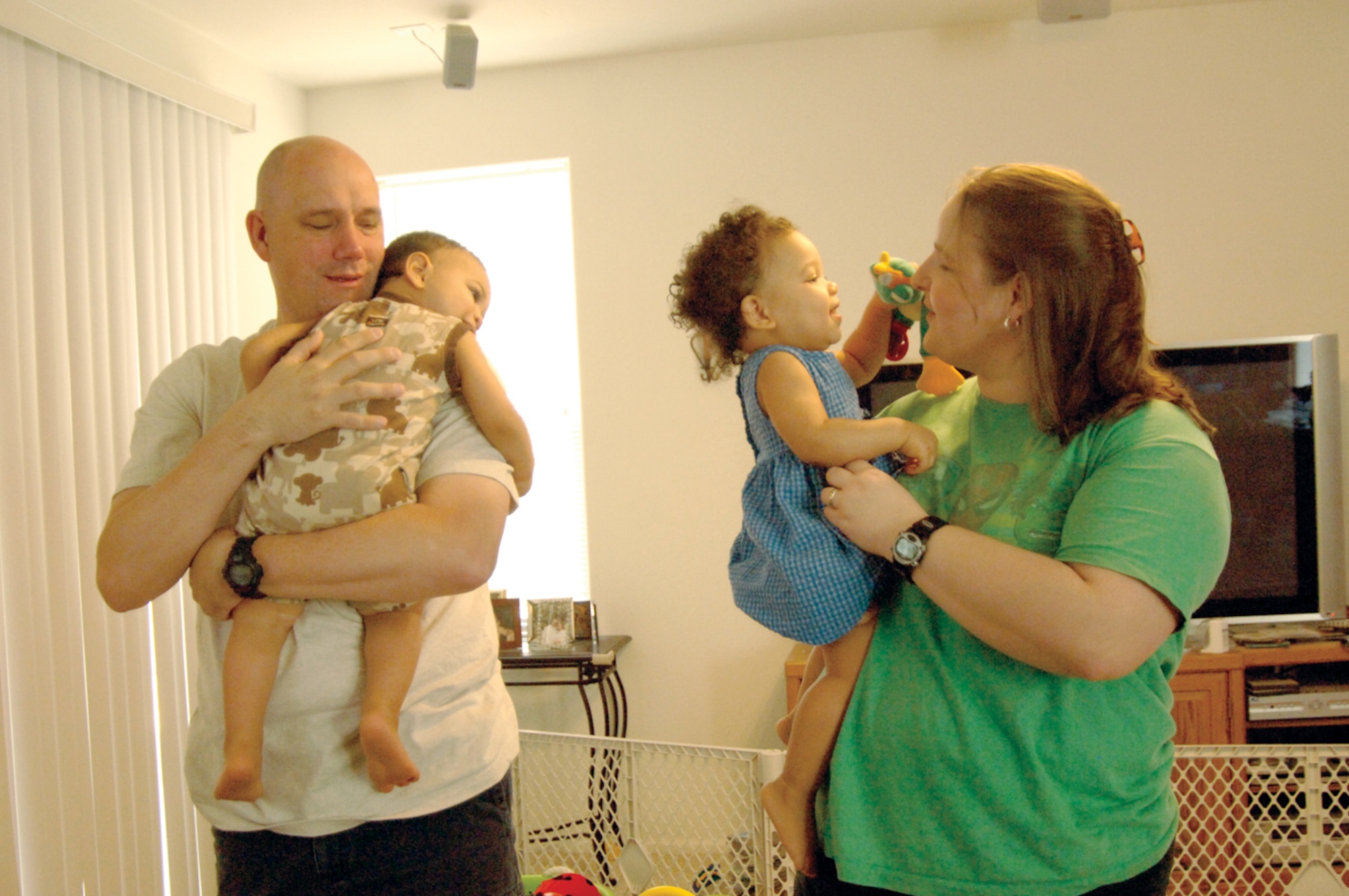 Jonathan Pervatt, 756th Aircraft Maintenance Squadron, and his wife, Faith, hold their adopted children, Grace, 1, and Benjamin, 1. (U.S. Air Force photo/ Deborah Silliman Wolfe.)