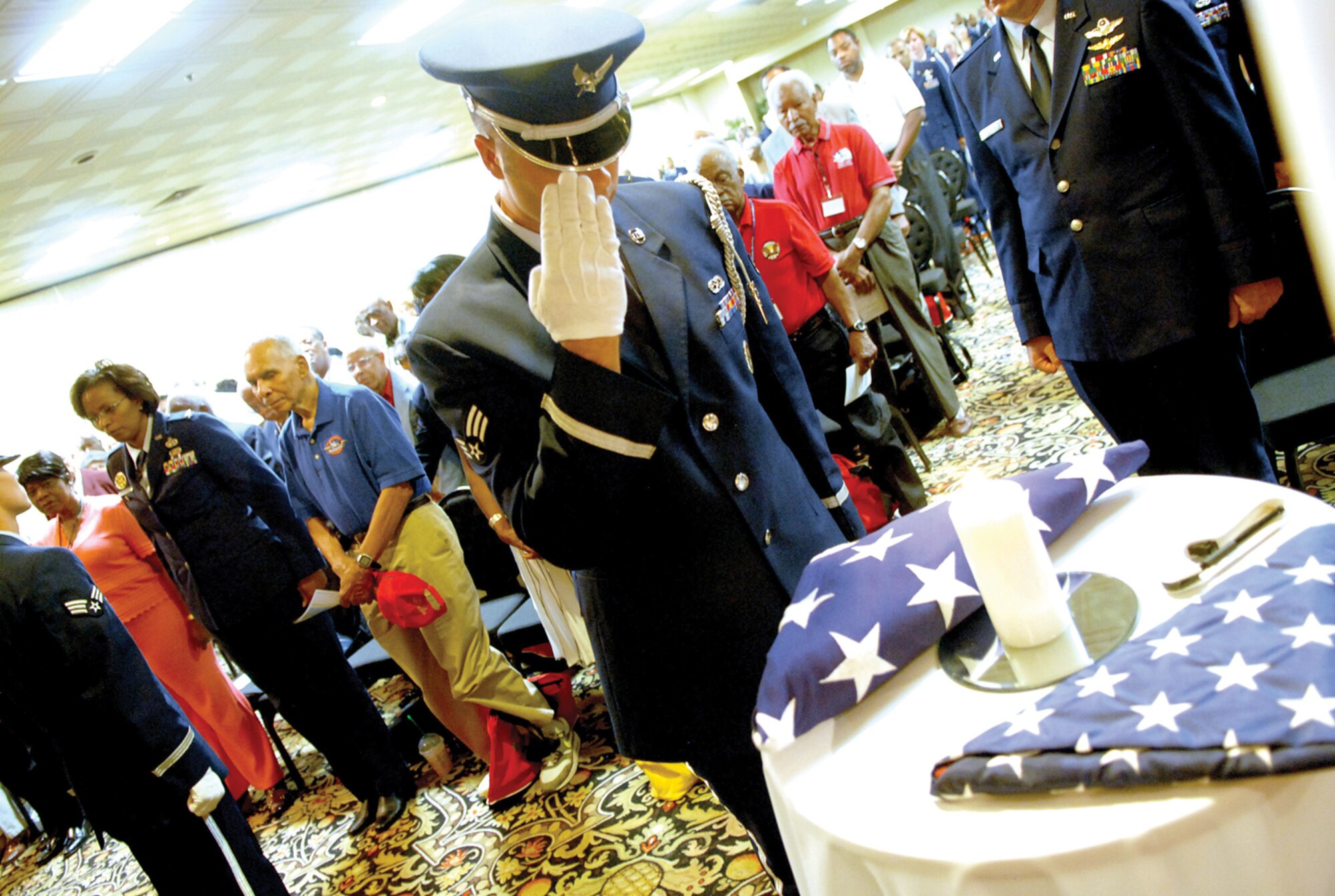 An Airman from the Nellis Air Force Base Honor Guard renders honors during the Lonely Eagle Ceremony that initiated the 38th Annual Tuskegee Airmen National Convention at the Palace Station Hotel and Casino in Las Vegas. The ceremony is a tribute to those Tuskegee Airmen who passed away the previous year. (U.S. Air Force photo/ Tech. Sgt. Jeffery Wolfe.)