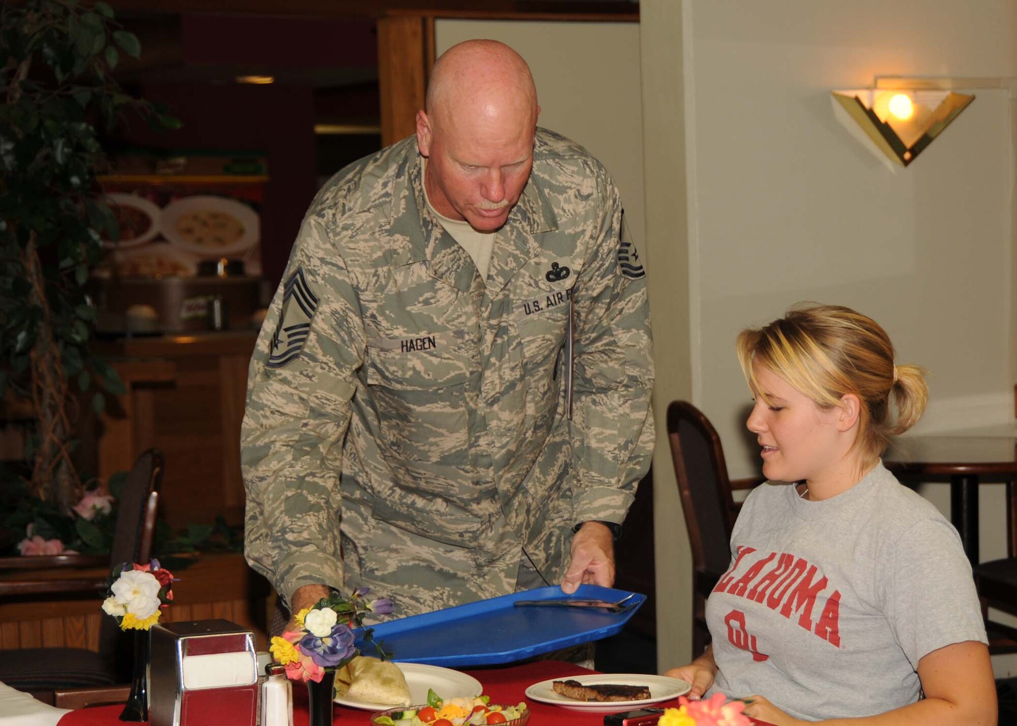 ALTUS AIR FORCE BASE, Okla. -- Chief Master Sgt. Mark Hagen (left), 97th Security Forces Squadron, serves a special birthday dinner to Airman 1st Class Amelia Leland, 97th Medical Group, at the Quarterly Birthday Meal at the Solar Inn Dining Facility Aug. 13. The birthday meal is one of the man quality of life initiatives implemented by base leadership to boost Altus Airmen’s morale. (U.S. Air Force Photo/Senior Airman Marianne E. Lane)