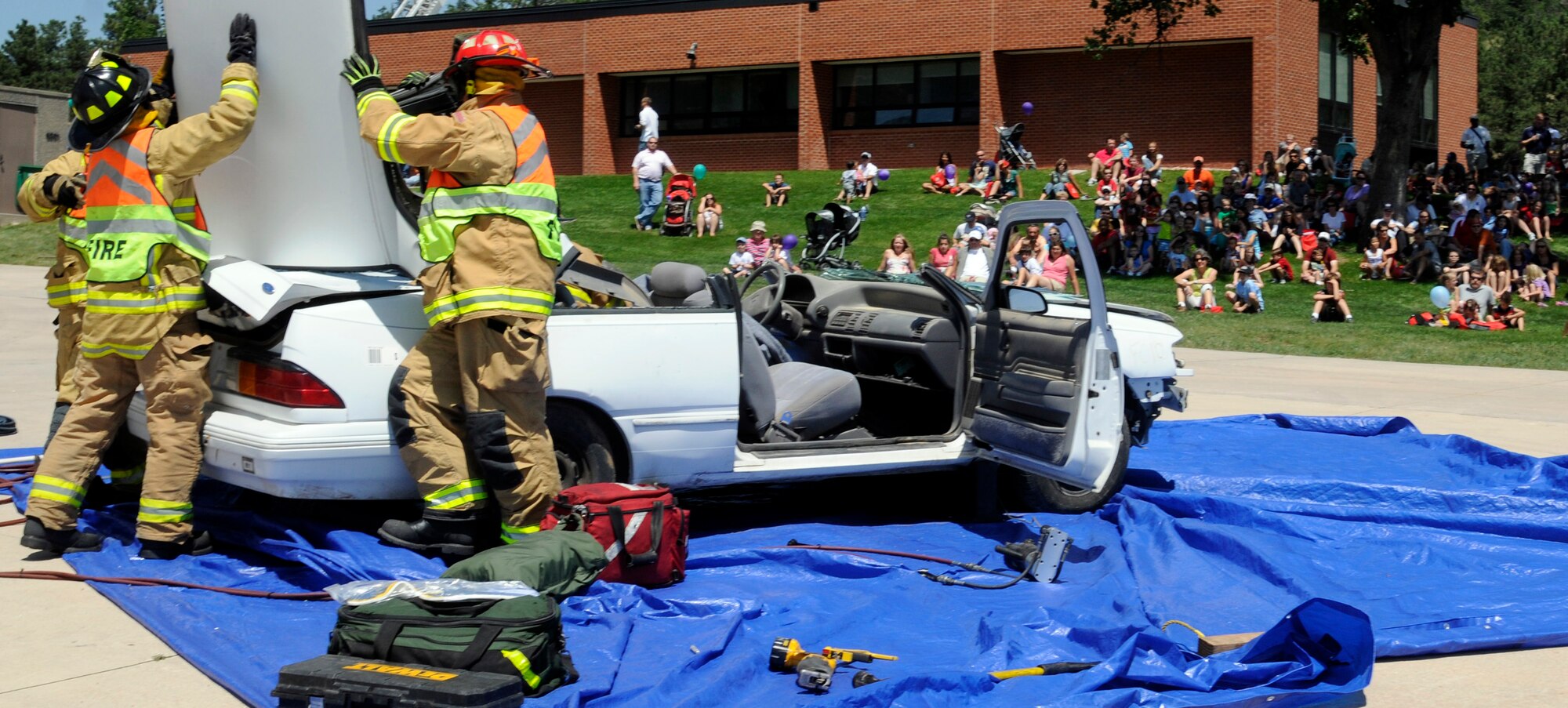 Firefighters demonstrate how they would rescue a victim from a vehicle during a demonstration at a U.S. Air Force Academy Fire Department Open House Aug. 8. The demonstration included heavy hydraulic tools used to pry open parts of a car for quick access to accident victims. (U.S. Air Force photo/J. Rachel Spencer)