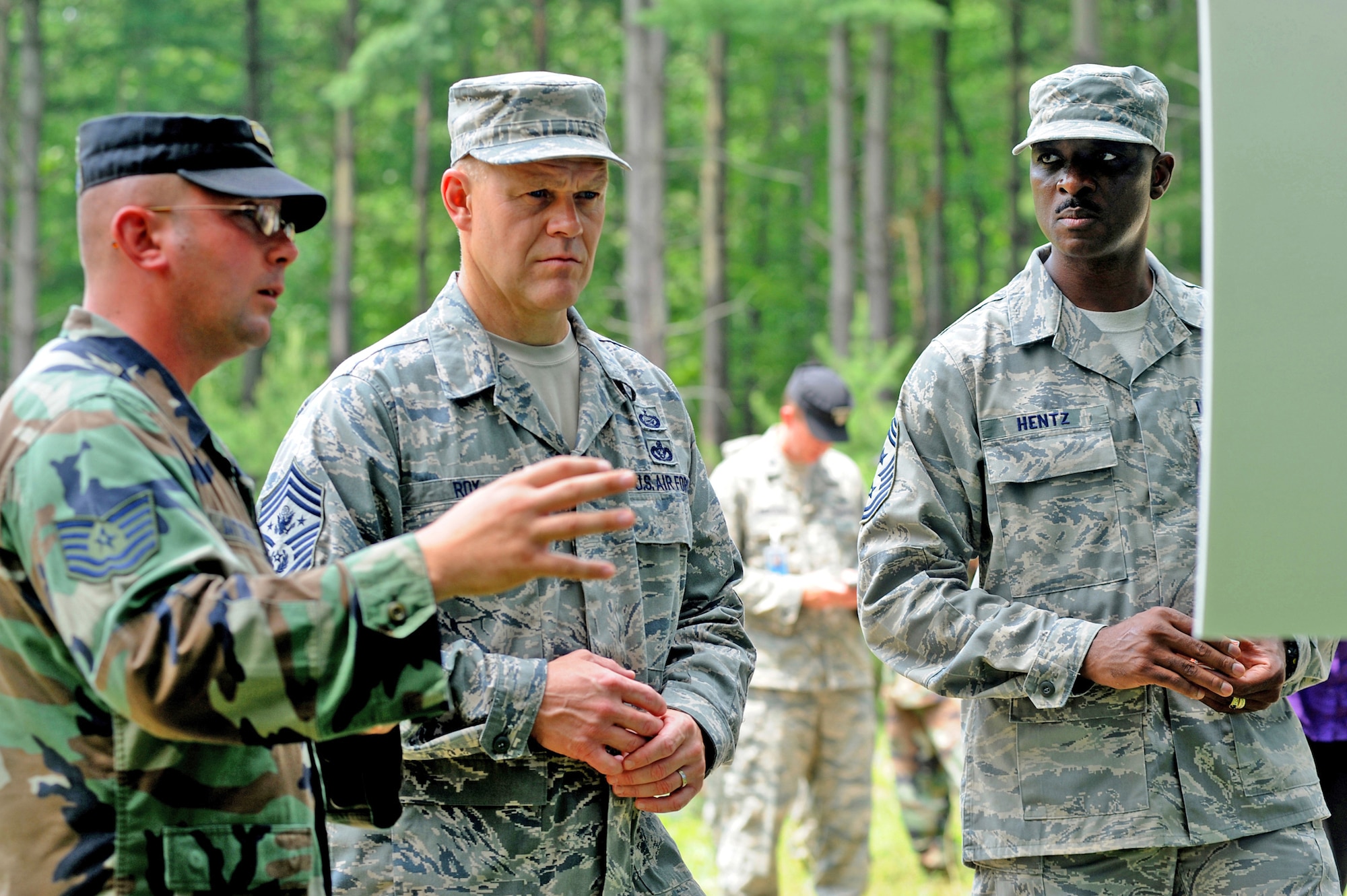 Tech. Sgt. Donald Satterlee briefs Chief Master Sgt. of the Air Force James Roy about advanced contingency skills training for Airmen while Chief Master Sgt. Fitzgerald Hentz listens. Part of the July 29 tour took place on a Fort Dix range on Joint Base McGuire-Dix-Lakehurst, N.J. Chief Roy visited the U.S. Air Force Expeditionary Center on Fort Dix and McGuire Air Force Base to learn more about expeditionary training and operations in both areas. Sergeant Satterlee is assigned to the U.S. Air Force Expeditionary Center's 421st Combat Training Squadron. Chief Hentz is the U.S. Air Force Expeditionary Center command chief. (U.S. Air Force Photo/Staff Sgt. Nathan G. Bevier) 